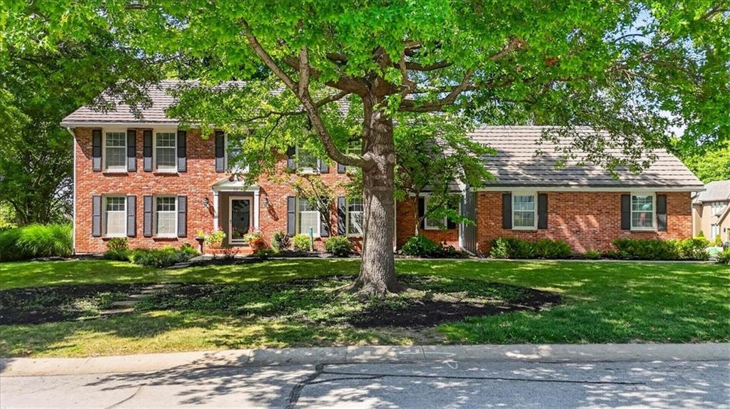 This custom-built, one-owner home offers exceptional living space on a beautifully treed, over 1/3 acre corner cul-de-sac lot. The impressive great room features a beamed ceiling, gas fireplace, custom built-ins, wet bar and a wall of windows overlooking the expansive deck and private backyard -- perfect for relaxing or hosting family and friends. Open to the great room, the eat-in kitchen offers abundant cabinetry, a breakfast bar and generous workspace. The formal dining room and living room offer versatile spaces for entertaining, working from home, or everyday living. A 1/2 bath and laundry room complete the main floor.  Fresh interior paint and new carpet on the main and upper levels make it truly move-in ready. Upstairs, you'll find 5 generously sized bedrooms, including a spacious primary suite featuring an ensuite bath with shower, double-sink vanity, Jacuzzi tub, and walk-in closet. The finished lower level is perfect for entertaining, complete with a second brick fireplace, wet bar, custom built-ins, large rec room, full bath, and abundant storage. Thoughtfully designed with generous room sizes, quality craftsmanship, and timeless appeal, this home also includes a durable stone-coated steel roof and an oversized 2-car side-entry garage (without shelves, two cars and a pontoon boat can fit). Enjoy all of the neighborhood amenities including lake access, boat rental, swimming pools, golf course, marina, parks, clubhouse, fitness center, tennis courts. Convenient location close to highways, shops, dining and top rated Blue Springs schools- Chapel Lakes Elementary, Delta Woods Middle and Blue Springs South High School!