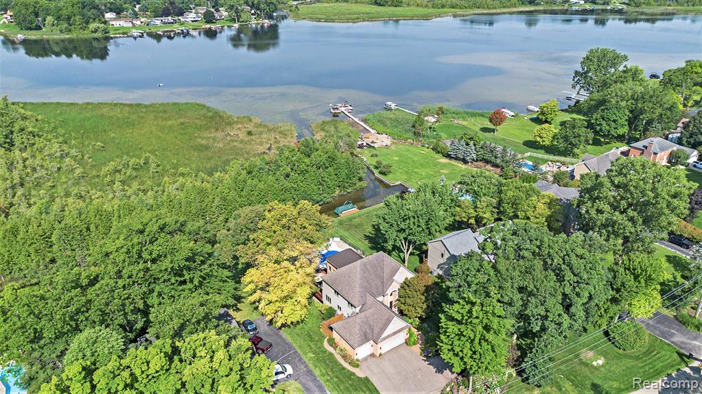 **Open House Saturday 10/4 11-1pm** Perfectly situated in the sought-after Waterford Hill community, this custom, impeccably maintained lakefront home offers the ultimate in luxury living on private, all-sports Greens Lake. Sited on a beautifully landscaped 0.54-acre lot with mature trees and lush greenery, this stunning residence is the epitome of lakeside elegance—complete w/ a saltwater pool. Step inside to discover a sun-drenched, open-concept interior adorned w/ gleaming hardwood floors & custom Pella windows that frame panoramic lake views. Soaring two-story ceilings in the home’s center create a grand sense of space, enhanced by a cozy fireplace & seamless flow into the living room. The chef-inspired kitchen is a dream—featuring quality cabinetry, quartz countertops, a custom island, and an inviting breakfast nook w/ sliding glass doors leading to expansive lakeside decking. Main-floor library offers an ideal remote work setup, while a well-appointed laundry room adds everyday convenience. Upstairs, the luxurious primary suite provides a true retreat, complete w/ generous closet space, a private balcony overlooking the lake, & a spa-style ensuite w/ dual vanities, a jetted tub, & a separate shower. Two add'l bedrooms, one w/a WIC, & a full bath offer comfortable accommodations, along w/ an airy loft perfect an office. The fin. walkout lower level adds over 1,800 square feet of living space warmed by a fireplace & featuring high ceilings, a full bath & ample storage. Discover an outdoor paradise—where a sparkling pool, BBQ area w/wet bar & 3rd fireplace, & spectacular lake views await. Addl. highlights include a heated 3.5-car garage w/ epoxy floors & extensive parking. Access to Van Norman & Lester Lakes and abutting serene Bay Court Park, offering unparalleled privacy and natural beauty. Inquire re: Clarkston Schools school of choice. Lovely gardens & showcased on 2018 Garden Walk. Don’t miss your opportunity to live the lake life without sacrifice! IDRBNG