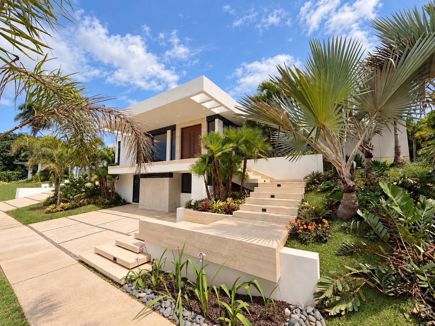 COMING SOON | Exceptional fully remodeled home in the highly sought-after Santa María community, offering expansive interiors, refined finishes, and impressive outdoor living spaces. Designed with an open, light-filled layout, the home features soaring ceilings, marble floors, generous living areas, and a spacious kitchen ideal for both everyday living and entertaining. The property offers five bedrooms and seven bathrooms, with each bedroom enjoying its own private en-suite bath.The primary suite is especially spacious, with direct access to the pool and outdoor areas. Its beautifully finished en-suite bathroom is complemented by two custom walk-in closets, creating a private and functional retreat.A versatile lower-level bonus area provides additional flexibility and can serve as a private office, entertainment space, guest quarters, or in-law suite. This level features its own entrance, bathroom, kitchenette, and elevator access connecting it to the main home.The outdoor areas are among the property’s most distinctive features. A large covered terrace with an outdoor kitchen opens to an expansive pool, jacuzzi, pergola, and beautifully landscaped grounds. Carefully selected greenery throughout the front and rear of the property creates a lush, polished setting for entertaining and relaxing.Additional features include a two-car garage and thoughtfully designed spaces throughout the home.Ideally located in Santa María, the property offers convenient access to some of Puerto Rico’s leading private schools, as well as supermarkets, pharmacies, restaurants, and everyday services. A beautifully renovated home combining space, versatility, quality finishes, and exceptional indoor-outdoor living in one of San Juan’s most desirable communities.