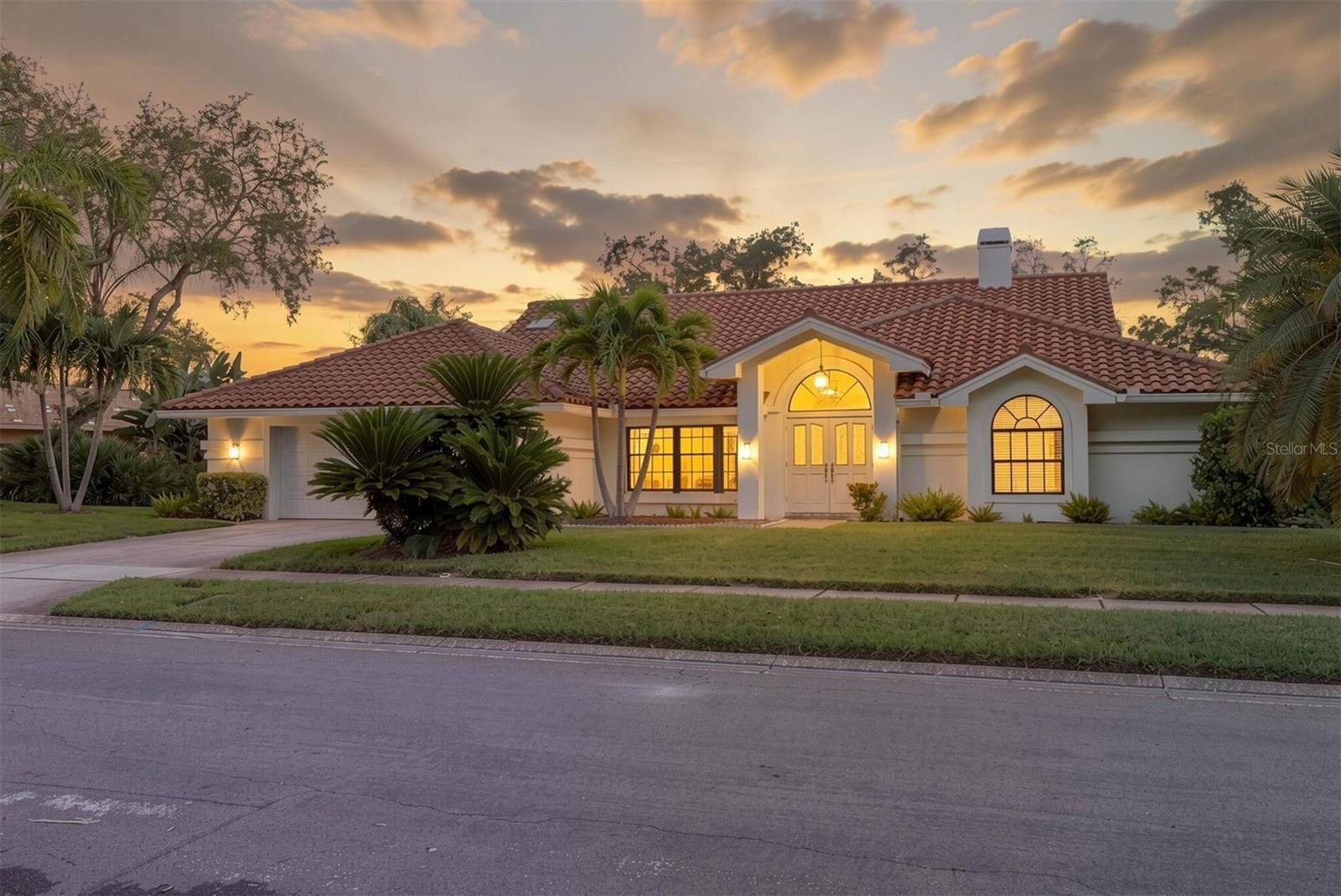 Set on a generous homesite in Country Woods, this 3-bedroom, 2-bath pool home offers more than 2,200 square feet of living space with a layout designed for comfortable everyday living and easy entertaining. The interior has been freshly painted and updated, newer lighting added inside and outside, creating a bright, clean, move-in-ready feel throughout. High ceilings, abundant natural light and large glass doors give the main living spaces an open, airy atmosphere, while the wood-burning fireplace adds warmth and character. The kitchen sits at the center of the home and opens naturally to the surrounding living and dining areas. Granite countertops, plentiful workspace and direct views toward the outdoor living area make it both functional and inviting. A split-bedroom design gives the primary suite added privacy. The spacious primary bedroom includes a walk-in closet, private bath and direct access to the pool area. Two additional bedrooms are positioned on the opposite side of the home near the second full bath. The outdoor space is a major highlight. A screened enclosure surrounds the heated saltwater pool and spa, creating a private setting for relaxing, dining and entertaining. The oversized lot provides mature landscaping and room to enjoy the Florida lifestyle without feeling crowded by neighboring homes. Additional features include hurricane protection, indoor laundry, a two-car garage with storage, irrigation and a low HOA fee. The property is also located in Flood Zone X-500. The location puts you within easy reach of Honeymoon Island, the Dunedin Causeway, Downtown Dunedin, Downtown Palm Harbor, Ozona, the Pinellas Trail, restaurants, shopping, breweries and the Gulf Coast. Close to all the Tampa Bay Area has to offer—championship golf courses, Tampa International Airport, world-class beaches, NHL, NFL and MLB events, the Grand Prix, PGA tournaments, fine dining, concerts, parks, biking trails and more. Begin Your Paradise Life Today.