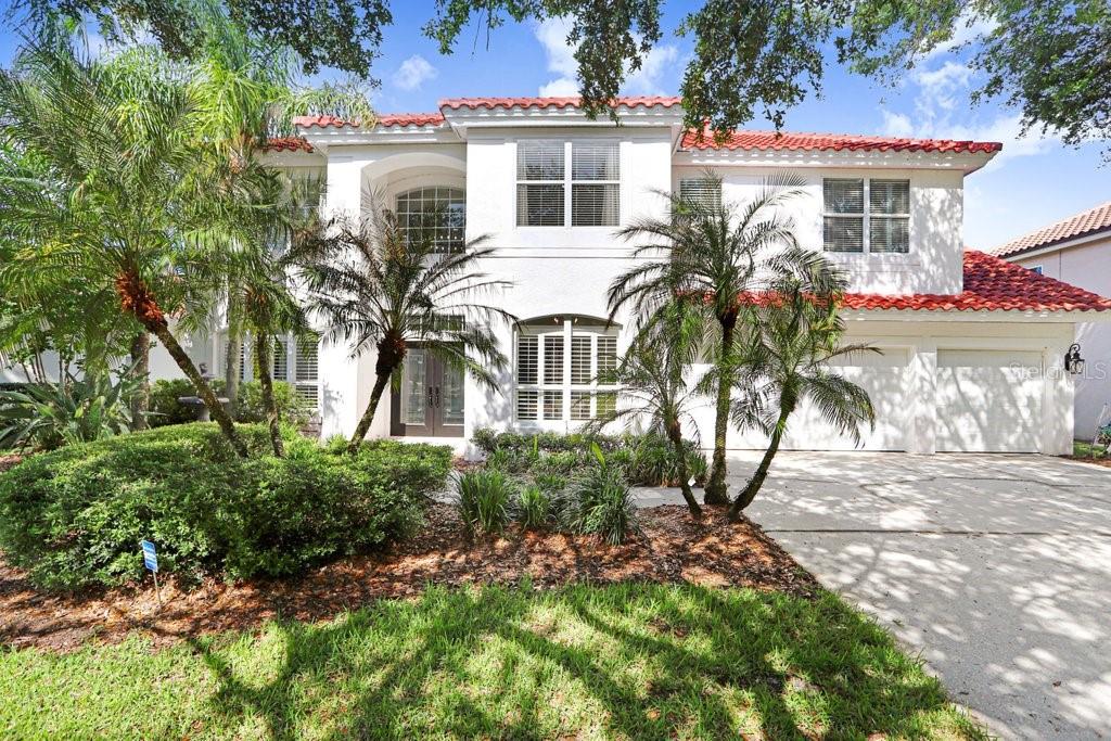Welcome to this stunning tile barrel roof, two-story pool home located in the highly coveted, gated and 24/7 manned community of Hunter’s Green in the heart of New Tampa. This beautifully appointed residence features 4 bedrooms, 2 full baths, a private office, powder room, and showcases serene conservation views. Step inside to soaring double vaulted ceilings in the entryway and formal living spaces, highlighted by a striking modern chandelier and an abundance of natural light. Elegant plantation shutters and light wood-look luxury vinyl plank flooring add warmth and sophistication throughout. The dedicated office, complete with 10-panel French glass double doors, provides the perfect work-from-home retreat. The spacious kitchen is designed for both function and style, featuring an island, 42” dark wood cabinetry, granite countertops, and stainless steel appliances. A cozy dinette area with glass sliders opens seamlessly to the covered patio, pool, and spa—ideal for indoor-outdoor Florida living. Upstairs, a charming two-way staircase with decorative spindles leads to an expansive luxury primary suite. This private retreat boasts a beautifully remodeled spa-like bath with a freestanding tub, oversized frameless glass shower with upgraded rainfall showerhead, dual vanities with quartz counters, a sitting area, and a private balcony overlooking the tranquil surroundings. Three additional generously sized bedrooms share a well-appointed bath with dual sinks and a tub/shower combination. Hunter’s Green offers an unparalleled lifestyle, blending suburban comfort with natural beauty. Set among 43 lakes and 65 acres of protected wetlands, residents enjoy 23 distinct enclaves and an array of amenities including bike lanes, playgrounds, lighted tennis, basketball, volleyball, soccer and baseball fields, a jogging trail with a 15-station fitness circuit, and an off-leash dog park. Optional membership to Hunter’s Green Country Club provides access to the 18-hole Tom Fazio-designed golf course and a premier tennis and athletic center. Adjacent Flatwoods Nature Park features a scenic 7-mile loop for biking, hiking, and bird watching. All of this, just minutes from abundant shopping, dining, and conveniences right outside the community gates. Roof (2020), HVAC (2021), Hotwater Tank (2025).