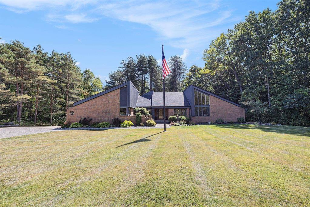 Welcome to 5220 Nardoni Lane in Dryden! This one-of-a-kind custom-built Mid-Century Modern retreat sits on 10+ serene acres and blends timeless design with modern updates. Featuring 25' vaulted ceilings and walls of windows, this home is filled with natural light and sweeping views of the property.  The spacious layout offers 3 bedrooms with an optional 4th downstairs, a dedicated home office, and a luxurious primary suite complete with a remodeled bath and doorwall access to the expansive deck. With 2.5 baths, abundant storage, and multiple living spaces, this home is designed for both comfort and function.  Step outside to your private paradise, where you'll find a lake with a dock, a pole barn, 5-car garage, and a sprawling deck with a hot tub-perfect for relaxing or entertaining.  This property combines striking architecture with peaceful country living, all within reach of town conveniences. Don't miss the opportunity to own this extraordinary home.
