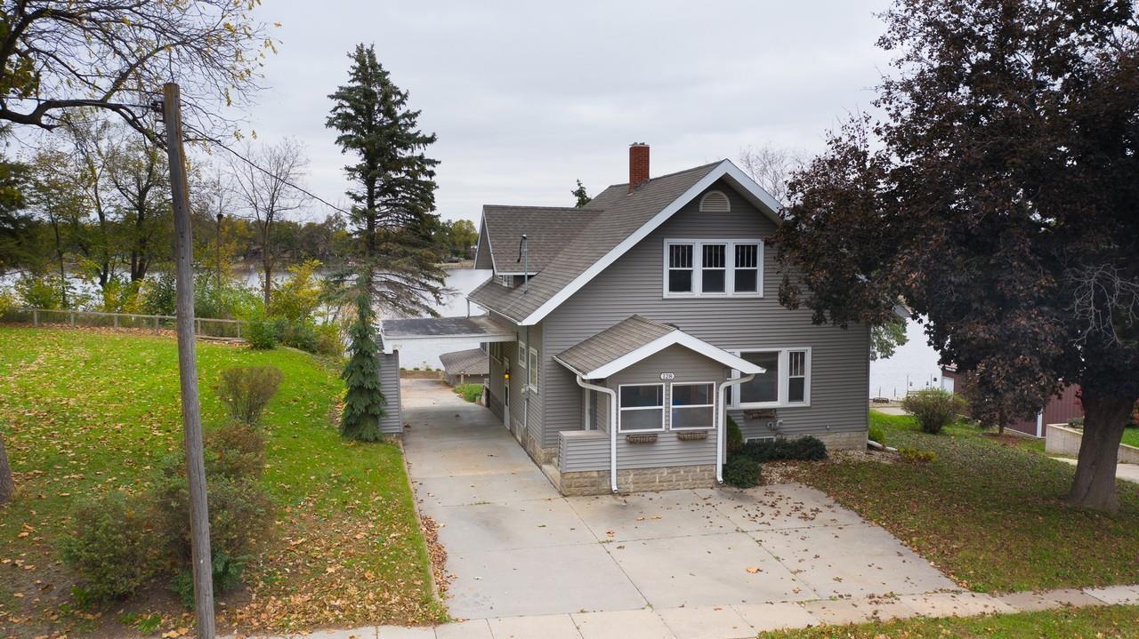 Stately charm and waterfront living come together at this distinctive one-and-a-half-story home situated along Cedar Lake in Nashua! Offering 81 feet of shoreline with a dock and an inviting setting adjacent to Cannon Park, this property presents a wonderful opportunity to enjoy lakeside living. The home features 3 bedrooms, 2 bathrooms, a spacious kitchen, and formal dining room, with beautiful woodwork throughout that showcases the craftsmanship and architectural details characteristic of its era. A delightful sunroom with two walls of windows captures picturesque views of the lake, while a main-level entry porch and finished upper-level sleeping porch add to the home's character and charm. A detached two-stall garage with an upper-level lookout provides additional space and a unique vantage point. Whether enjoying beautiful sunsets, fishing, boating, or simply relaxing along the shoreline, the outdoor possibilities are plentiful. With Cannon Park next door and downtown Nashua just a short walk away, this property offers a distinctive combination of location, character, and Cedar Lake lifestyle!
