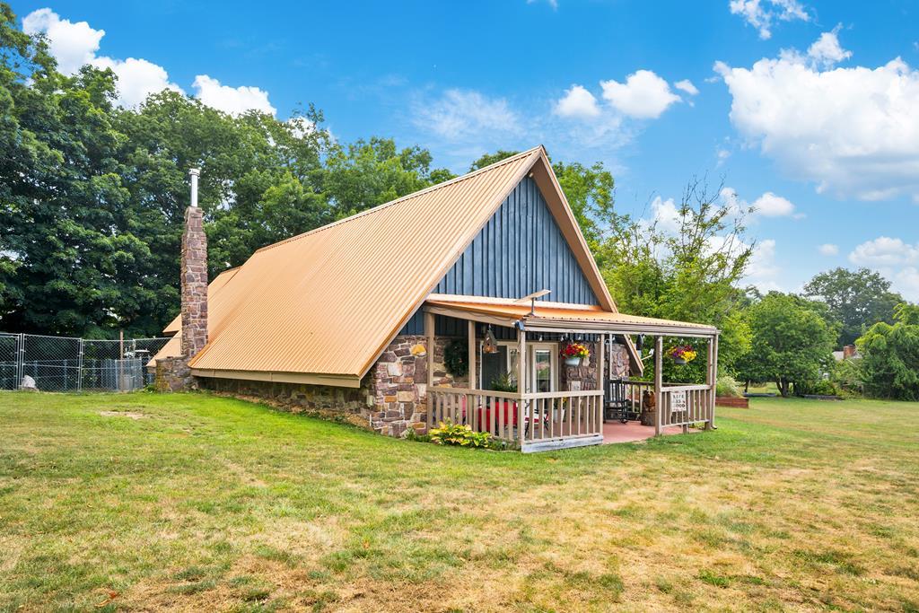 A taste of Gatlinburg here in Southwest Virginia! Are you looking for a place convenient to I-81 and I-77 and like to entertain? Well check out this amazing A Frame in Fort Chiswell! Set on an acre of land, this home boasts nearly 1900 square feet, with three bedrooms and two baths. This well kept property has been tastefully updated with new flooring on the ground level and handcrafted touches throughout. The heat pump and metal roof are both less than five years old. A two car garage includes an extra space currently used as a butcher shop/wood shop and also has a walk in cooler! But the best part of this property is the entertaining space out back. With a fire pit, hand made live edge black walnut tables and a hand made bar with refrigerator and TV, you'll be ready for cookouts and entertaining! The primary bedroom upstairs has a balcony that overlooks the entertainment space. This would also be an excellent Airbnb with its convenience to the interstate and country charm. The predominantly open front yard is sprinkled with a few fruit trees and could be home to many football games or park as many vehicles as you need for family reunions. The raised beds on the side yard offer an excellent spot to grow a garden. Stone on the side of the house is locally sourced. There is even a playhouse/pets house with a heater! This is an amazing home with so many possibilities! Schedule your showing today!!