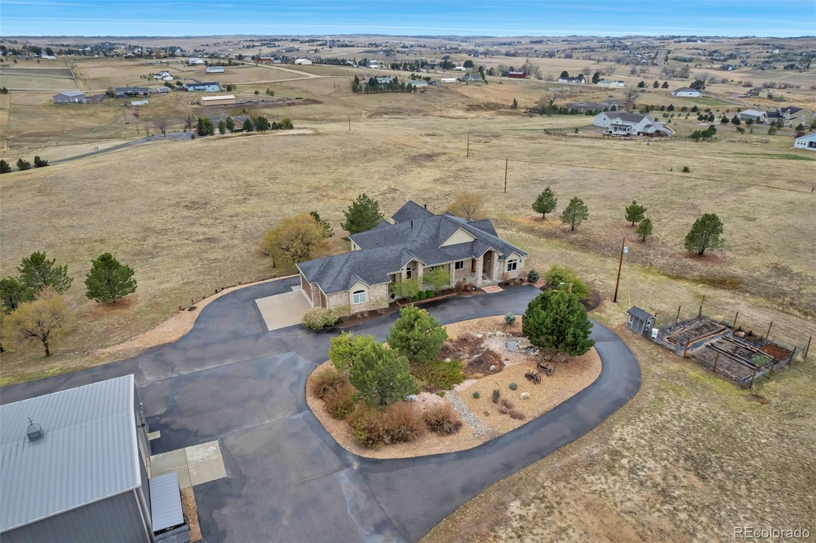 Set on over 15 breathtaking acres, this exceptional property offers the perfect blend of luxury, privacy, and sweeping mountain views from nearly every room. Thoughtfully designed with high-end finishes throughout, the home welcomes you with soaring vaulted ceilings in the family and dining rooms, creating a light-filled and inviting atmosphere. The family room is anchored by a stunning floor-to-ceiling stone fireplace and walnut hardwood floors while the gourmet kitchen showcases unique hand-chipped granite countertops. To top it off you'll find a built in nook with safety deposit bars from the Denver Bank, perfect for the home wine cellar or library nook.The primary suite is a true retreat, complete with a gas fireplace, spacious walk-in custom closet, and the convenience of an in-suite washer/dryer. The spa-inspired 5 piece primary bath offers a luxurious steam shower and jetted soaking tub, providing the perfect place to unwind.  Step outside to enjoy the expansive covered composite decks accessible from both the kitchen and primary suite, ideal for taking in the stunning Colorado landscape and year-round outdoor living.The walk-out basement is designed for both entertaining and everyday living, featuring a fully equipped wet bar, billiards room, home theater, game room, and dedicated home gym—offering something for everyone. You'll also enjoy two additional large bedrooms.You'll appreciate the attached three-car garage, fully finished with sheetrock and durable epoxy flooring. In addition, the property truly shines with its impressive 3,000-square-foot outbuilding, equipped with an electric heater, water hookups, 50-amp power, a concrete floor, and RV-sized garage doors with smart automatic openers—perfect for storing equipment, recreational vehicles, or creating a workshop.This rare offering combines luxury living with wide-open space and unmatched amenities, all set against a backdrop of incredible mountain views and the ability to have horses