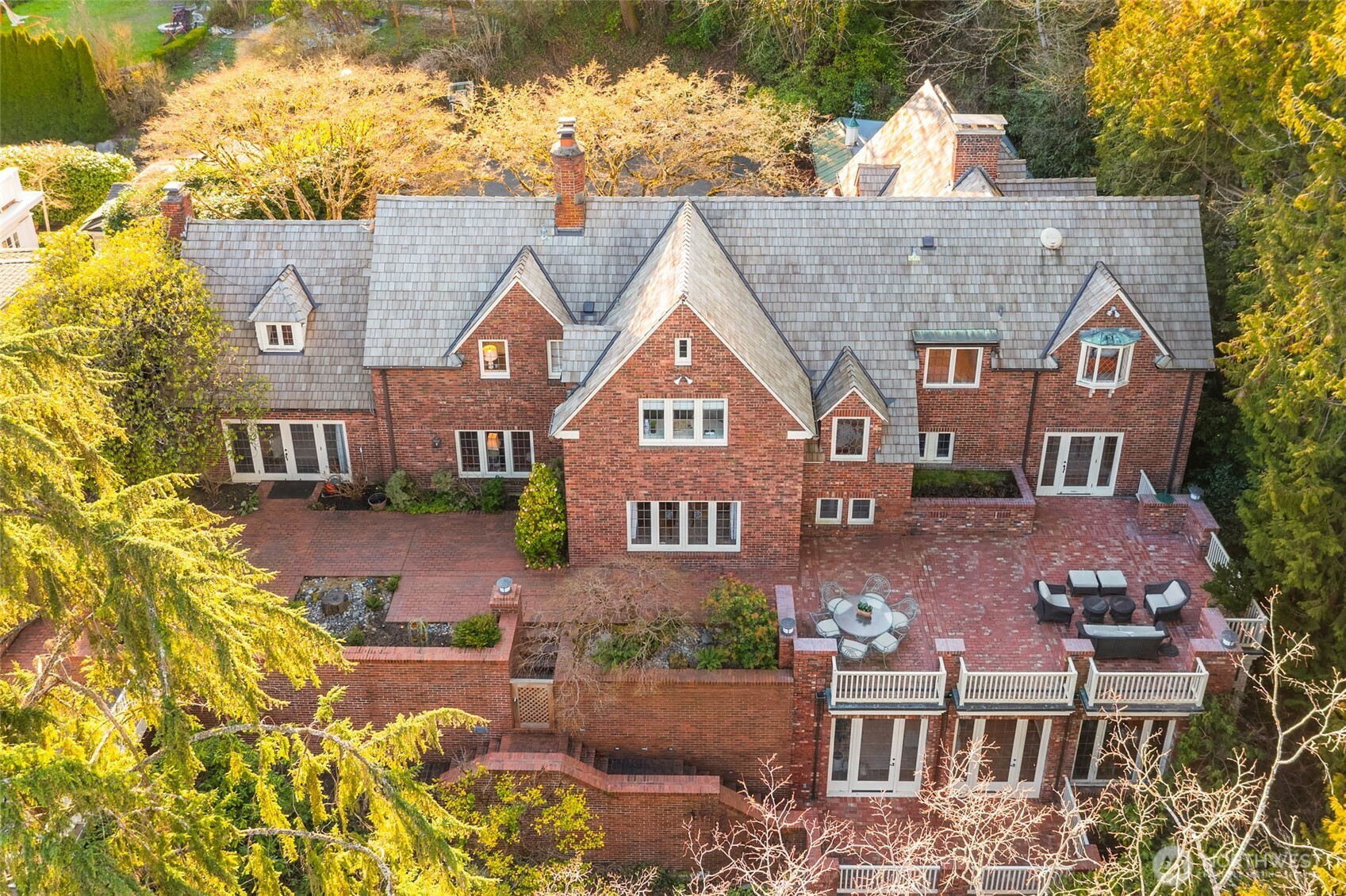 An Award Winning Arthur Loveless designed English Tudor Estate discreetly sited at the end of a private Denny-Blaine cul-de-sac to blend historic English charm with the lush, secluded scenery typical of Seattle’s most quiet neighborhood. Recognized for its design excellence with the prestigious Honor Award from the American Institute of Architects (AIA), the home has been featured prominently in publications on Arthur Loveless and Northwest design. The residence’s Tudor Revival architecture is inspired by the English Country Estate; full of character and charming details, featuring classic wall dormers, bay windows, and a signature recessed entry defined by elegant Tudor arches and intricate brickwork in a herringbone pattern. Just above, a private gabled balcony with handcrafted wood trim adds a final touch of craftsmanship to the facade. Charming English Cottage details throughout; fairytale themed stained glass windows, hand-painted tiles and whimsical fixtures add a touch of fairytale to the masterpiece. While maintaining its historical integrity, the property has been updated for modern living with the addition of a spacious family room and a grand modern kitchen, merging  1920s elegance and the needs of modern living.