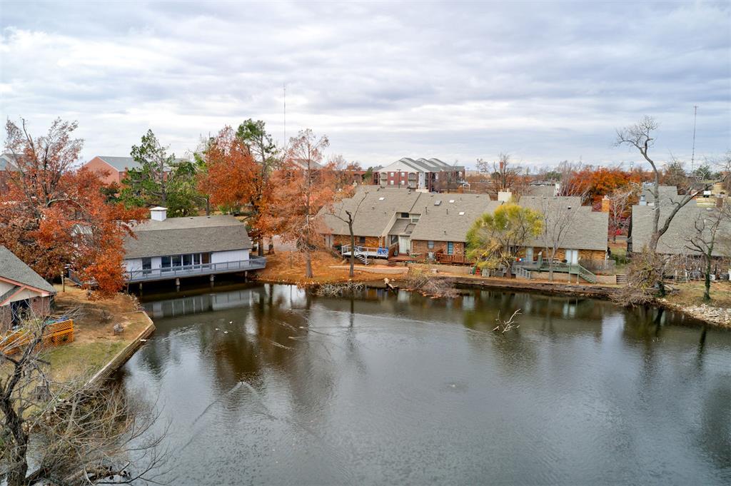 Lakefront, two-story townhome in gated SE Edmond community with 2 bedrooms, 2 full baths, and attached 1-car garage. The high ceilings, wood-look flooring, quartz countertops, ample barstool seating, and a fireplace that divides the living and dining areas, all work together to create a luxurious ambiance. The main floor includes a bedroom and full bathroom, and the 545 sq ft loft that overlooks the living room, also has a full bath, making it ideal as a second bedroom, office, or personal retreat. The property backs up to a serene lake, and the private deck offers a perfect spot to take in the view. Guest parking is conveniently nearby, and the clubhouse is available to rent for gatherings. The HOA fee covers 2 gated entrances, lawn care, exterior painting, common areas, and exterior insurance. Take advantage of nearby Eagle Trail for walking and biking. These homes sell fast, so schedule your viewing today!