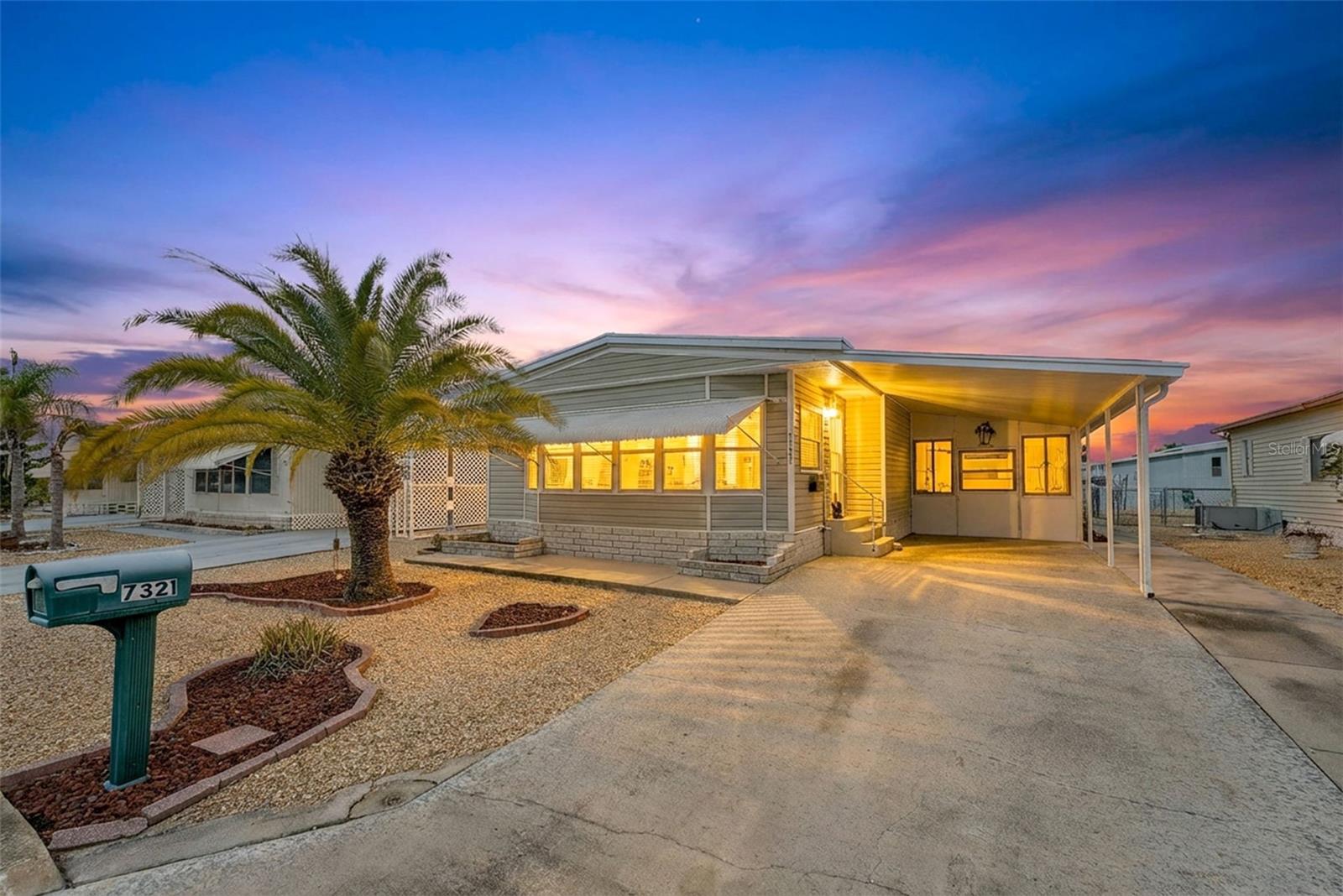 Move-in Ready and spacious 2 bedroom 2 bath home in desirable Ponderosa Park, close to shopping, restaurants, Gulf Beaches and an easy ride to Tampa Airport.  This Community offers an amazing heated pool, active clubhouse, on-site community office, bocci and shuffleboard, all for only $250 per YEAR, and you own your land!!  No Lot Rent!  This home is super clean, and loaded with upgrades, including metal roof-over, enclosed workshop, easy care gravel lawn, screened lanai, awnings, upgraded windows, and best of all, mostly furnished!  Out back, enjoy the custom built raised deck and relax!!  Everything in the photos are included in the sale!!  Inside, there's loads of room, with 1394 square feet of living space, huge living area, central kitchen, cavernous primary suite, all appliances including washer and dryer, luxury plank flooring, meticulous paint throughout, No reason to look any further, this home has it all!!