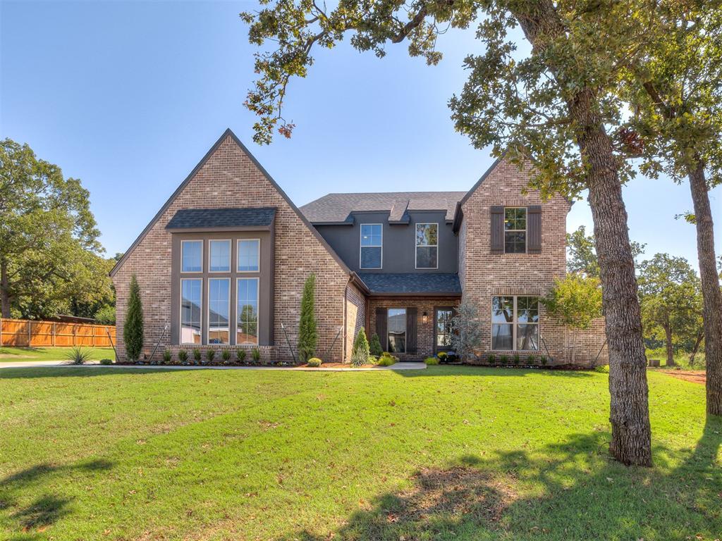 This stunning new construction home is filled with timeless character. From the tudor inspired exterior and tall windows to the welcoming front porch, the curb appeal makes a lasting impression. Inside, the open living room is anchored by a soaring vaulted ceiling and a floor to ceiling stone fireplace. Natural light fills the space, highlighting all of the designer touches. 
The chef’s kitchen is truly a design masterpiece, offering a spacious island with seating, custom cabinetry, luxury appliances, and a striking backsplash. Windows above the counter open directly to the back porch creating a unique indoor to outdoor connection perfect for effortless entertaining. The owners suite is privately tucked away and features a spa-like bathroom with dual vanities, a soaking tub, a walk in tiled shower and an oversized closet with custom shelving.
Three additional bedrooms provide generous space, complemented by a full guest bath and a stylish powder bath. A dedicated study with bold design offers a perfect work-from-home setup, while the upstairs bonus room provides flexible living space for a game room, theater, or playroom. An additional unfinished room upstairs allows for future expansion. The backyard offers wooded privacy and a covered patio for relaxing evenings or outdoor gatherings. Located in the gated Timberland Creek community within Edmond Schools. Welcome Home!