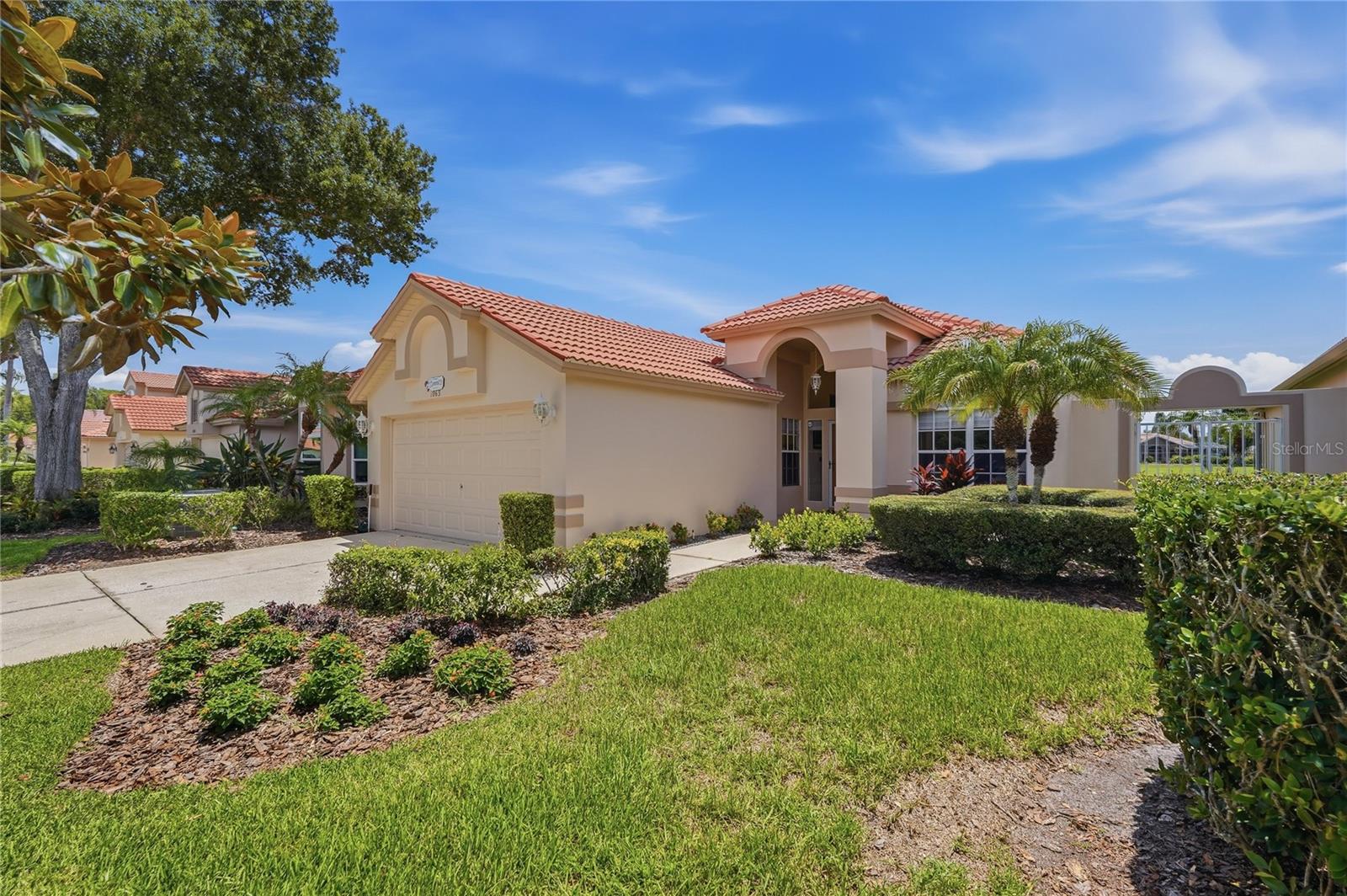 Welcome to 1063 Dartford Drive, a beautifully maintained villa in the guard-gated community of Crescent Oaks Country Club. With 1,953 square feet of comfortable, maintenance-free living, this inviting home features 2 bedrooms, 2 bathrooms, and a versatile den that may serve as a third bedroom, home office, or guest retreat. The spacious eat-in kitchen is enhanced with stone countertops, custom cabinetry, convenient pull-out shelving, and deep storage drawers. An open living and dining area flows seamlessly leading to the three-panel sliding glass doors out onto  the screened lanai.  Complete with an outdoor kitchen—perfect for relaxing or entertaining year-round. Additional improvements include a new water heater and water softener installed in 2025, new honeycomb window shades, and refreshed landscaping in both the front and rear yards. Crescent Oaks residents enjoy access to an 18-hole golf course, tennis, pickleball, clubhouse, restaurant, and bar, all just steps from home. Conveniently located near Tampa International Airport, St. Pete-Clearwater International Airport, local restaurants, shopping, Gulf beaches, and the world-famous Tarpon Springs Sponge Docks. Schedule your private tour today and discover resort-style living in one of Tarpon Springs’ most desirable communities.
