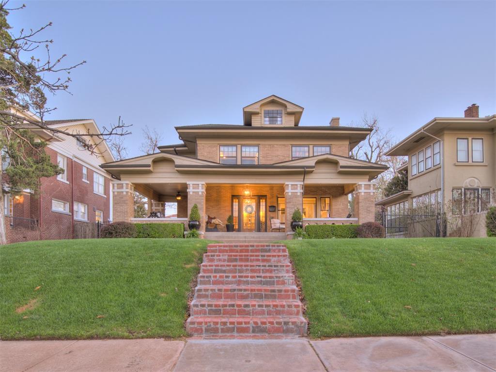 Fully renovated from the studs up while preserving its 1918 charm, this Heritage Hills home blends historic character with modern luxury. Spray-foam insulated and updated with all-new electrical and plumbing, the living room welcomes you with coffered ceilings, a marble gas fireplace, a large window framing the covered front porch, and dual entries—one to a dramatic saddleback staircase. The dining room impresses with tall wainscoting and artful wallpaper, plus a swinging door that leads to a hidden wet bar. Designed for a serious home chef, the vast kitchen features full-size refrigerator and freezer, double ovens, a striking Calacatta Gold marble island, custom soft-close cabinetry, an exposed brick flue, and French doors that open to a generous pantry and a convenient half-bath on the stair landing. The cozy den, with its rich wood entry and warm wood-planked ceiling, is the room you’ll gather in most. Upstairs, three bedrooms include a master suite with both a large walk-in shoe closet and a separate walk-in clothes closet, and a sumptuous marble master bath with marble floors, counters, and a spacious shower. The largest bedroom opens to the attic—an ideal playroom or creative space. Outside, the shaded covered front porch and a new concrete patio with a fireplace create perfect entertaining spaces, and practical upgrades include a new driveway and sewer line. Come see this beautifully reimagined historic home.