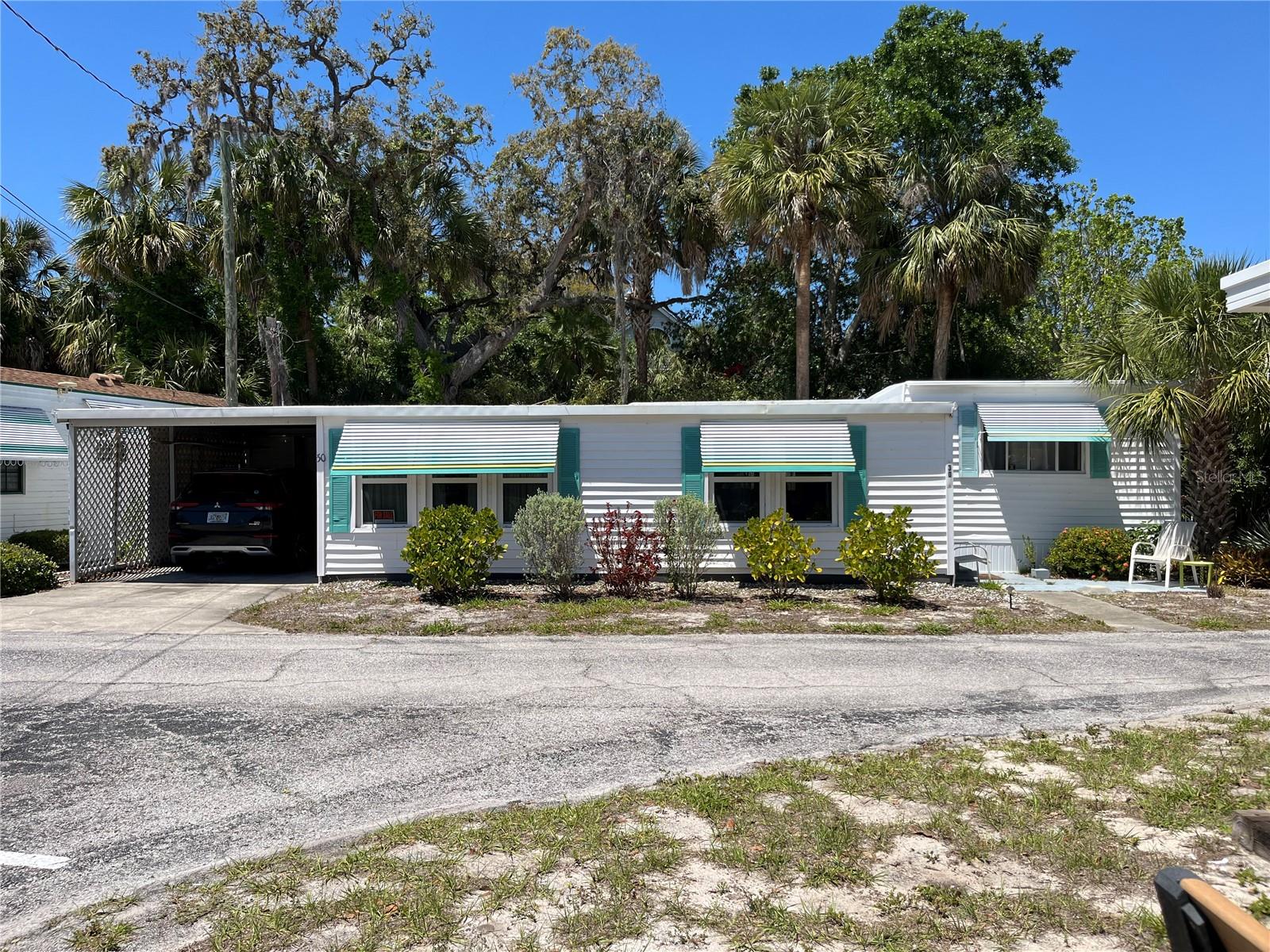 PEACEFUL, PRIVATE & PRIME LOCATION!  Gulf front community with NO lot rent - LOW HOA dues.  Launch your kayak or canoe & head out for a paddle from your community dock; hop on the adjoining Pinellas Trail for a bike ride, run or walk; amble over to the 210 acres of Wall Springs Park to enjoy the nature trails, observation tower, butterfly garden or fishing piers.  If you're just staying home, your back porch/patio offers your own secluded escape - fenced, surrounded by bamboo/plants, no rear neighbors - perfect for curling up with a book, enjoying drinks with friends or quiet daydreaming!  Colors, rafter ceilings & artistic painted bar area provide a cozy 'chic' interior.  Remodeled bath, flexible bonus room, covered parking & outside storage complete the package. Park amenities include shuffleboard court, clubhouse, fire pit, water view picnic area & large dock for sunset viewing!  Come join this small, friendly, 55+ community where you 'own' a share of paradise!