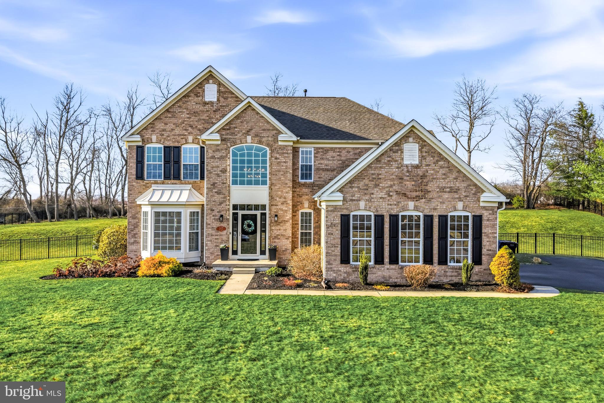 Welcome to 207 Dillons Lane in the highly desirable Dillons View community, tucked away on a quiet cul de sac in Mullica Hill. Set on a beautiful one acre property with a classic brick façade and great curb appeal, this home offers thoughtful updates and a layout designed for comfortable everyday living.Step inside to a bright and airy two story foyer, where a large window fills the space with natural light and creates a welcoming first impression. New flooring throughout the first floor creates a seamless flow across the main living spaces.Just off the foyer, the formal living room opens naturally into the formal dining room, creating a great setup for holidays, entertaining, or simply having additional space to gather. As you continue toward the back of the house, the space opens up into the heart of the home.The family room is warm and inviting and centers around a beautifully redesigned gas fireplace with shiplap, a neutral tile surround, and a floating wood mantle. From there, the room flows directly into the updated kitchen, which features white cabinetry, a center island with gas cooktop, new stainless steel appliances including the refridgerator, cooktop, downdraft and dishwasher, and a classic subway tile backsplash. Just beyond the kitchen is the sun filled breakfast area, a perfect spot for morning coffee while overlooking the backyard.French style glass doors lead to the back elevated patio with a retractable awning, offering the ideal place to relax or entertain while taking in the peaceful views of the fully fenced backyard and expansive acre of land. A newly installed shed provides convenient storage for outdoor equipment and toys.The main level also includes a convenient laundry with newer premium washer and dryer, and mudroom just off the attached two car garage, complete with a utility sink, storage cabinets, and countertop space to help keep everything organized. The garage has a Level 2 EV charger that was recently added, as well as additional storage space.The second floor offers four bedrooms, including a spacious primary suite and three additional bedrooms with ample closet space. The secondary bedrooms share a beautifully renovated hall bathroom with double vanities, while the primary suite features a large ensuite bathroom with double sinks, a soaking/jetted tub, separate stall shower, and a huge walk in closet.The finished basement adds even more flexibility, with a large open space perfect for a recreation room, media room, playroom, gym, or home office. There is also excellent storage throughout, and the space is plumbed for a future bathroom should the next owner ever want to add one.Outside, the driveway has recently been resealed and provides plenty of additional parking, while the expansive property with a 13-zone irrigation offers a wonderful balance of privacy and usable outdoor space.