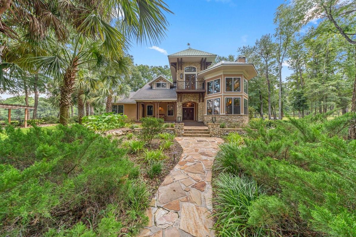 SADDLE UP! Privately nestled on approximately 40 breathtaking acres, this extraordinary 4-bedroom, 3.5-bath, 3,298-square-foot custom equestrian estate, designed by renowned local architect Jay Reeves, combines architectural artistry, luxury and exceptional privacy. Completely secluded from the road and surrounded by mature hardwoods and majestic oaks, the home is filled with natural light. The dramatic great room features soaring 24-foot cypress ceilings, custom beams and a magnificent wood-burning fireplace crafted from hand-selected tan river rock with a locally made Red Oak mantle. Twelve-foot ceilings continue throughout the bedrooms and baths, while knotty alder doors, custom cherrywood cabinetry and millwork, sinker-cypress accents, granite surfaces and designer lighting showcase exceptional craftsmanship. The gourmet kitchen and cherrywood wet bar are designed for entertaining, with the kitchen overlooking a beautiful rear paddock. The primary retreat features a custom sinker-cypress wall, walk-in closet system and spa-inspired bath. Sonos sound, smart-home security, landscape lighting, fiber optics, automatic gated entry and a standby generator serving the home, barn and main well complete this thoughtfully designed estate.The Exceptional Equestrian Facilities:  17-stall barn with 12'x12' individually lit stalls, each with two electrical outlets and custom fan racks. Amenities include a feed room, 3 indoor and 2 outdoor lighted wash racks, climate-controlled tack room, fly-control system, ceiling fans, cupola ventilation and 220V power for shop equipment. The property features 9 fenced paddocks, each with dedicated water and old-growth oaks for shade, plus 5 run-in sheds. Approximately 3 miles of private, predominantly shaded riding trails with eventing jumps provide the rare opportunity to ride and train without leaving the property. The impressive 176'x256' custom arena features clay-and-sand footing with dedicated irrigation to keep it jump-ready. A private 1-bedroom, 1-bath barn apartment with two entrances, spacious kitchen and laundry provides ideal accommodations for a trainer, caretaker or guests. Additional features include an RV/horse-trailer electrical outlet, two 90-gallon fuel tanks and extensive irrigation. Private, sophisticated and meticulously designed, this remarkable 40-acre estate offers an extraordinary opportunity to live, ride, train and entertain at home.  WELLS & SEPTIC: The property is served by two wells. The farm well is an industrial 6-inch well installed by Freeman in 2018 under the supervision of a professional geologist. This well services the whole property.  A separate residential well, located to the left of the main residence, was constructed in 2000 is the back up well.   It can be run by a standalone generator if the main generator fails, it can be run by a switch on a panel on the south side of the house in case the big well needs servicing.  The residence well has a pipe connecting to the barn so the barn also has water in case of something failing.  The property also has two septic systems, which are serviced annually. The residence septic is located to the left of the home, while the barn septic is located behind the barn.