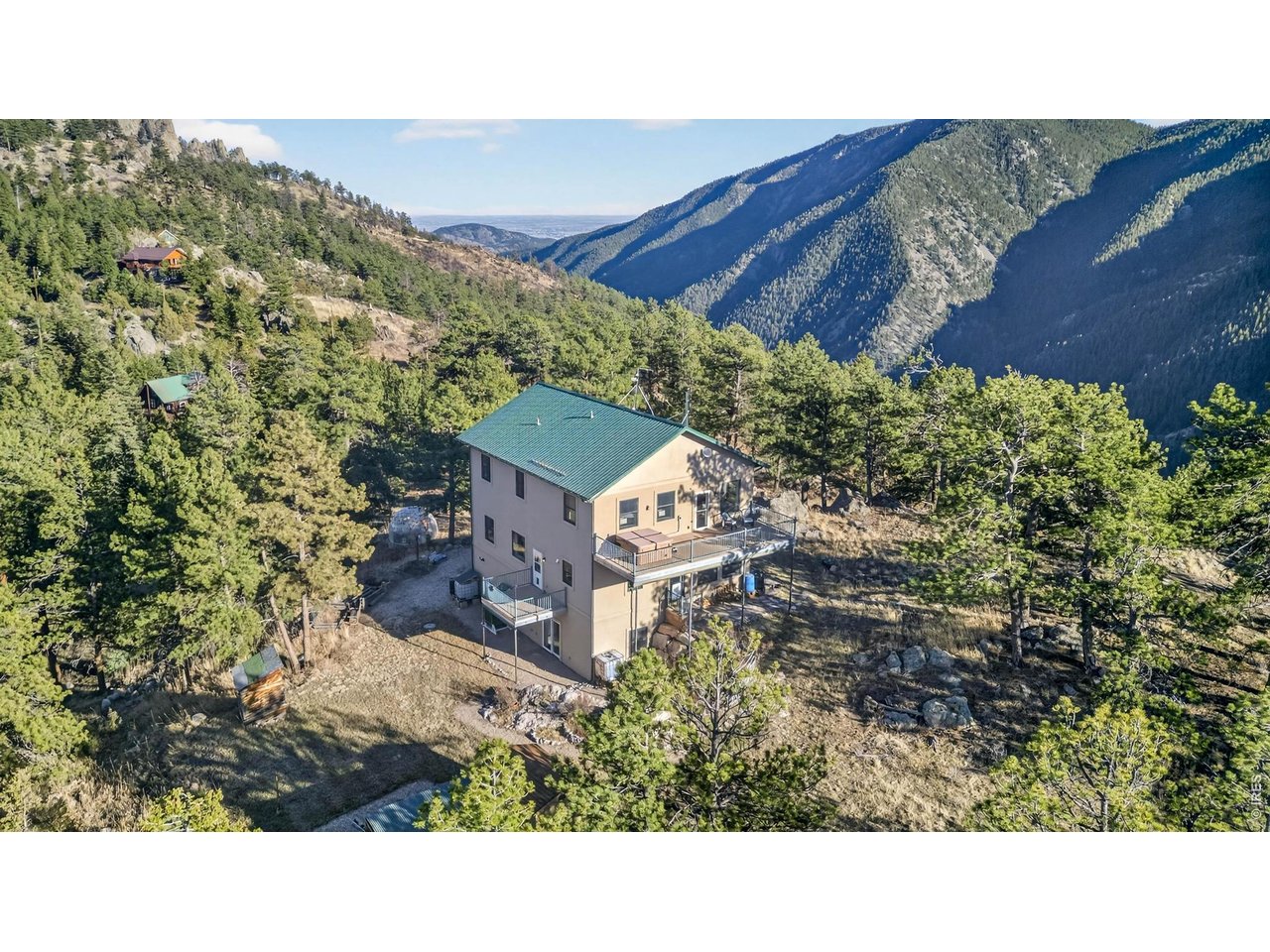 Spanning over 3,500 square feet, this 4bedroom, 4bath home was constructed with performance and longevity at the forefront. Built using insulated concrete form construction, reinforced with steel framing, and finished with two concrete-and-steel decks, a durable metal roof and stucco exterior, the home provides exceptional insulation, fire resistance, and low upkeep ideal for mountain environments. These construction features increase the fundamental long-term value of the property, allowing it to stand out from most other market offerings. The durability and energy efficiency of ICF construction, while more expensive to build, is key to that goal, with a 30-50% ongoing reduction in energy costs. The concrete-and-steel decks are comparatively maintenance free. Metal roofing is generally considered to have a 50-year lifespan. The foresight to include unused wiring conduit throughout will serve as both solar power technologies and wired communications technologies evolve over the years to come. Experience elevated mountain living in a one-of-a-kind custom residence set on nearly 7 secluded acres.At the end of a private road and surrounded on 3 sides by Roosevelt National Forest, this property offers uninterrupted views.Inside, expansive living spaces are designed to capture natural light and showcase the surrounding landscape.The flexible layout includes 2 primary bedroom suites, making it well-suited for extended stays or shared living arrangements.The kitchen is outfitted with custom wood cabinetry, generous prep space, a walkin storage pantry Comfort and reliability are prioritized with multiple heating systems, and woodburning stove Property is also equipped with backup power capability, upgraded electrical service, and protective systems designed for year-round dependability. greenhouse structure, storage buildings. Water infrastructure is designed for efficiency and sustainability, with high-capacity storage, delivery support. Estes Park and Loveland close.