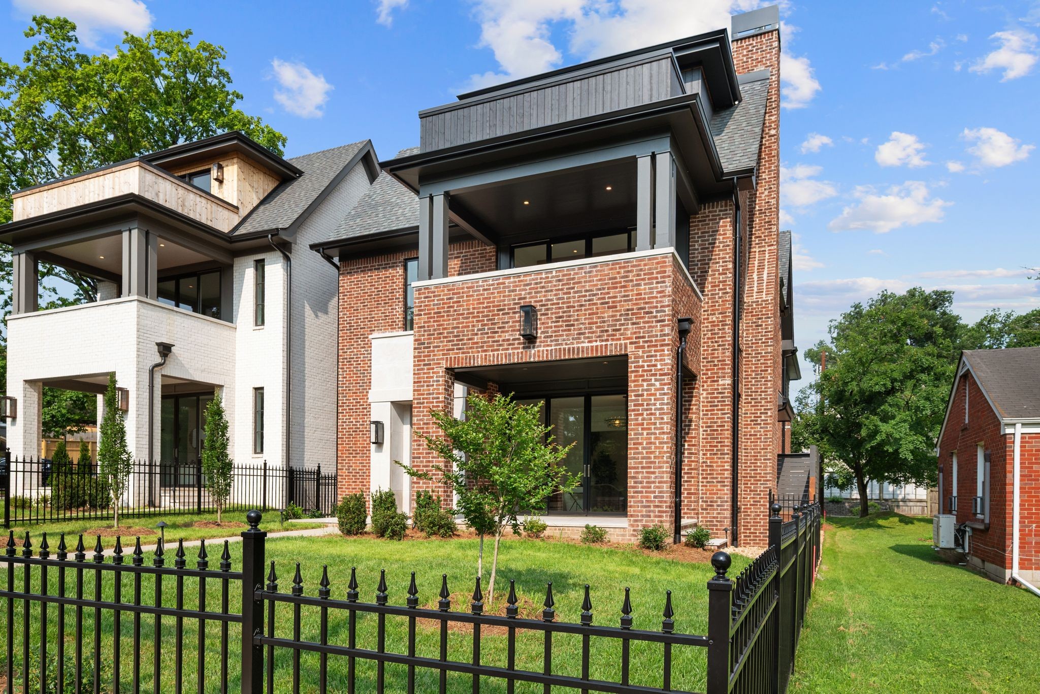 Exquisite All-Brick New Construction with Panoramic Park Views in the Heart of Belmont/12 South! This stunning home overlooking Sevier Park combines architectural sophistication with refined livability, a short walk from the vibrant restaurants and shops of 12 South. Designed by Allard Ward and masterfully built by Sabia Construction, every element of this home reflects thoughtful craftsmanship and timeless elegance. A striking entry welcomes you with custom iron-and-glass doors framed in cut limestone, opening to a sun-drenched main level anchored by soaring ceilings and wide-plank white oak hardwoods. The open-concept living and dining areas feature bespoke built-ins and a dramatic fireplace with fluted stone surround, flowing seamlessly through full-width glass doors to a covered limestone porch, perfect for elevated indoor-outdoor entertaining. The chef’s kitchen is a showcase of form and function, boasting handcrafted cabinetry, slab backsplash, a 48” Miele range, paneled refrigerator/freezer, and a spacious walk-in pantry. A dedicated library-style office offers a quiet retreat for work or study. Upstairs, the luxurious owner’s suite invites you with a private balcony, dual walk-in closets, and hotel-style spa bath featuring a freestanding Kohler soaking tub and designer finishes. Three additional bedrooms, each with walk-in closets and ensuite access, are complemented by a generously sized laundry and utility room with custom cabinetry. The top floor is an entertainer’s dream, offering a spacious lounge with wet bar, tailored paneling, and a treetop balcony with sweeping park views. A half bath, large flex room ideal for a gym, studio, or second office plumbed for an additional full bath complete this versatile level. Access all floors via a striking custom staircase or your private elevator. Outdoor living space includes a private ipe-decked side porch, fully landscaped grounds with irrigation and lighting, and custom ornamental metal fencing.