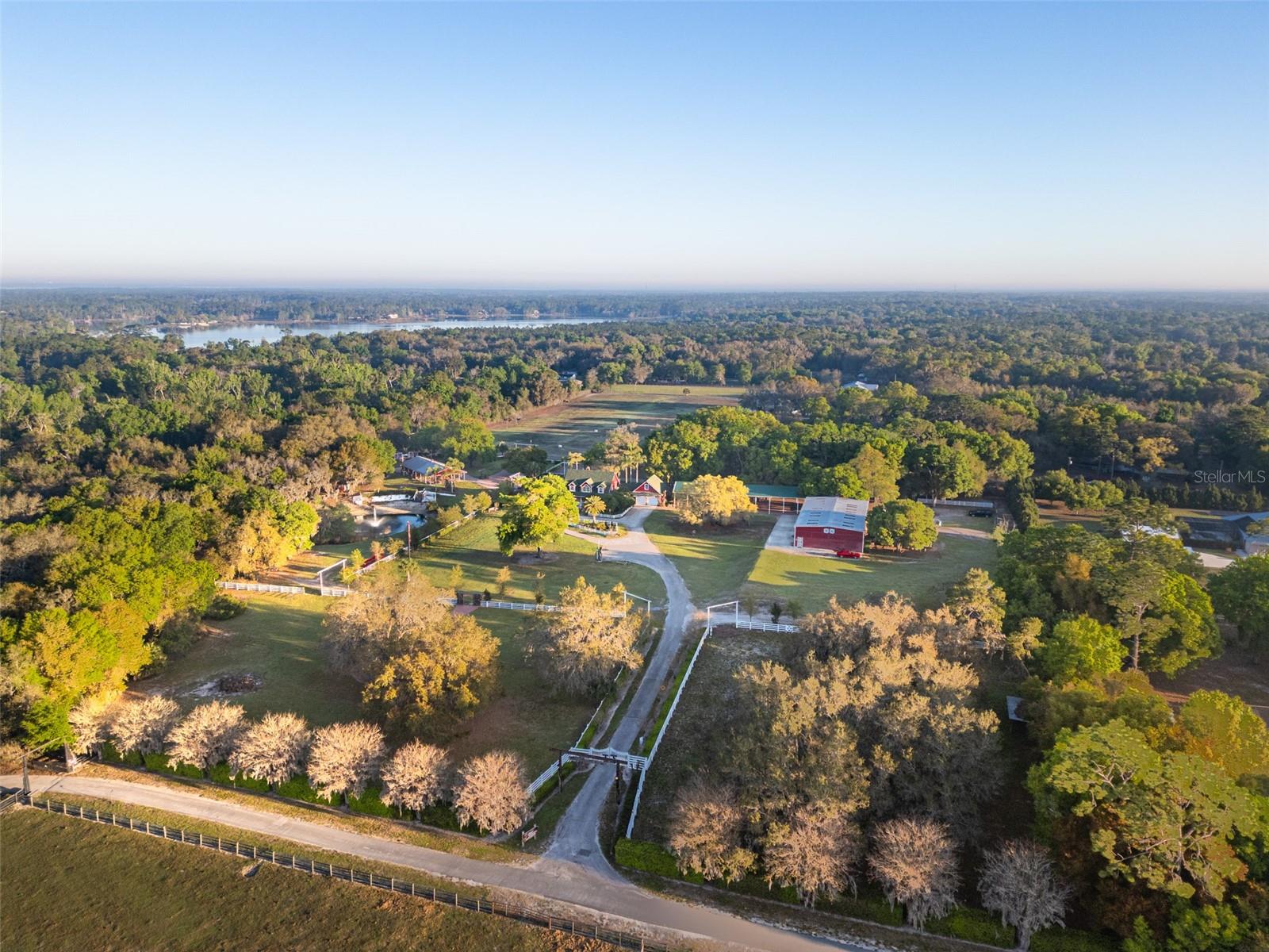 An exceptional and rare offering in Central Florida’s scenic horse country, Horsepower Ranch presents a remarkable opportunity to acquire a private estate, income-producing business and equestrian retreat all in one. Ideally positioned within the desirable Snow Hill/Geneva corridor of Eastern Seminole County, this roughly 21.75-acre property is thoughtfully designed for both lifestyle and functionality, blending natural beauty with a well-established events operation. At the heart of the property is the main residence, a charming three-bedroom, 3.5-bath pool home encompassing approximately 1,985 square feet. The interior is warm and inviting, highlighted by vaulted ceilings, a wood-burning fireplace and a first-floor primary suite. Expansive windows and a screened pool create a seamless connection to the surrounding landscape, while a picturesque covered front porch offers a welcoming vantage point overlooking the entrance to the ranch. A secondary single-story residence, approximately 1,375 square feet, features three bedrooms, one bath and its own wood-burning fireplace, ideal for guest accommodations, staff housing or multi-generational living. Designed to support both equestrian and event operations, the grounds are exceptionally well-equipped. A five-stall stable, a corral with seven paddocks and multiple outbuildings cater to a variety of agricultural and livestock needs, while a 2,600-square-foot pole barn provides additional covered storage, parking or flexible-use space. A 4.76-acre tree farm further enhances the property’s versatility and long-term value. The crown jewel of the ranch’s commercial component is the impressive 5,300-square-foot finished entertainment barn, thoughtfully designed for gatherings and events. This expansive structure includes a full-service bar, an upstairs loft, a private enclosed room suitable for an office or caretaker’s quarters, a full bath and five oversized overhead doors, allowing for an open-air atmosphere that seamlessly blends indoor and outdoor entertaining. Currently operating as a successful wedding and corporate events venue, Horsepower Ranch offers a unique turnkey business opportunity. A comprehensive list of event-related items that convey with the sale further supports continued operations or future expansion. The property also features a petting zoo with livestock, enhancing its appeal for both private and public events. Outdoor enthusiasts will appreciate the property’s direct access to the Geneva Wilderness Area via a private gate along the western boundary, offering immediate connectivity to miles of scenic trails for horseback riding, hiking and biking. Additional nearby destinations include the Little Big Econ Jones East Trailhead, Little Big Econ State Forest and the Little Big Econlockhatchee Wildlife Management Area. Despite its tranquil, secluded setting, the property remains conveniently located approximately 45 minutes from Orlando International Airport and the pristine beaches of Florida’s east coast, delivering a rare balance of privacy, accessibility and opportunity. Horsepower Ranch is a distinctive legacy property, offering endless possibilities for those seeking a refined rural lifestyle, an established business or a one-of-a-kind investment. Please see attachments for document showing addresses/parcel I.D.'s/legal descriptions for all properties included in the sale of this property.