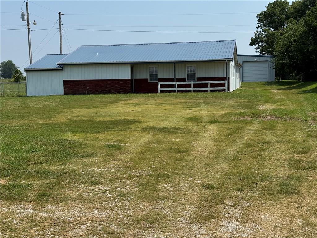 An investment opportunity! What was once a restaurant building became a daycare, then a residence.  This ranch style building with metal siding and brick facing will need to be repaired in the interior. There is a kitchen, utility room and two 1/2 baths. Most of the building is open. 
Behind the building is a 40 X 60 red iron frame insulated metal building with a concrete floor and a bathroom with shower. There are three overhead doors and one walk-through door. The two buildings are on  2.8 acres on South Highway 32, 2.2 miles south of  El Dorado Springs