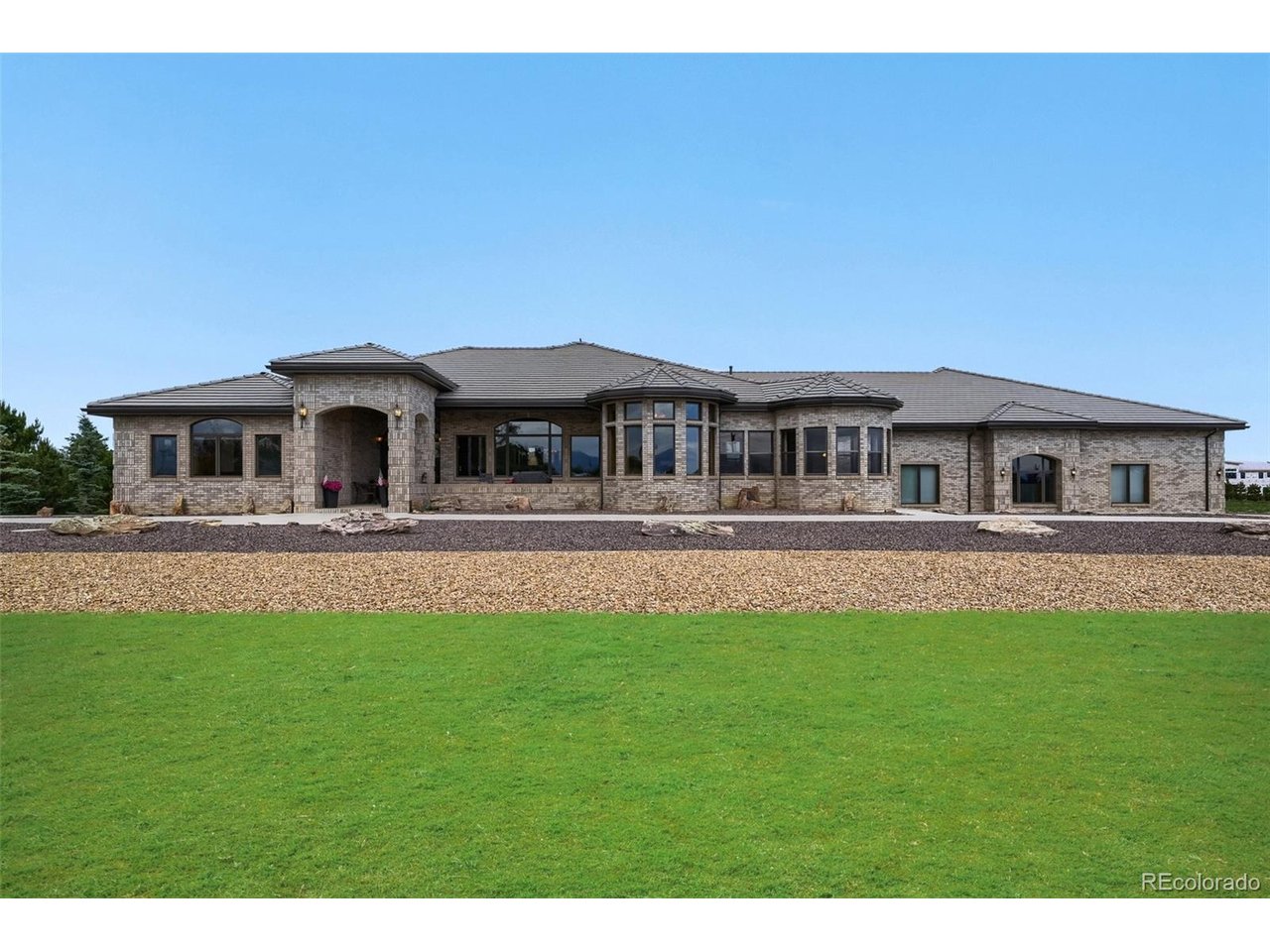 Once-in-a-Lifetime Opportunity to Own a Beautifully Landscaped Luxury Estate of Approximately 4.5 Acres, Showcasing Breathtaking Colorado Mountain Views and Exceptional Natural Surroundings. This custom-built residence offers an exceptional blend of privacy, elegance, and open space. Rich hardwood flooring spans the main level, complementing the home's timeless craftsmanship and inviting atmosphere.The chef's kitchen is designed to impress with newer top-of-the-line stainless steel appliances, custom cabinetry, granite slab countertops, an expansive center island, breakfast bar seating, and a generous walk-in pantry. It seamlessly combines beauty and functionality for everyday living.Designed for both entertaining and comfortable living, the home features a spacious great room, elegant formal dining room, and a well-appointed butler's pantry. The sunroom provides a stunning year-round setting to enjoy Colorado's sunshine and mountain views. The private primary retreat offers an oversized custom walk-in closet and a luxurious five-piece bath, creating the perfect place to unwind.The crown jewel of this remarkable estate is the massive 15,275 sqft custom brick building with an additional 2,400 sqft mezzanine. Offering incredible versatility, it is ideal for car collectors, automotive enthusiasts, RV owners, home-based businesses, and secure storage of specialty vehicles and equipment. The building includes a private office, two bathrooms, heat throughout, expansive open bays, and endless possibilities for storage, collections, or home-business use. Whether you're showcasing a prized automobile collection or pursuing passion projects, this exceptional facility delivers a level of utility rarely found on the market.Conveniently located with easy access to E-470, I-25, Downtown Denver, and Denver International Airport, this one-of-a-kind estate offers the perfect combination of luxury living, privacy, accessibility, and unmatched shop space.