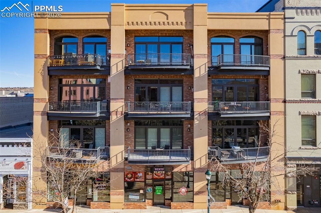 Experience true downtown loft living in the heart of Colorado Springs. This modern loft offers an open, airy layout filled with natural light, high ceilings, and a functional design ideal for both everyday living and entertaining. The spacious living area flows seamlessly into the kitchen, which features stainless steel appliances, a gas range, and ample cabinetry, while a gas fireplace adds warmth and character to the space. Large windows bring the city into your home, and step outside to the private patio overlooking Tejon Street, complete with a gas fire pit, perfect for relaxing or entertaining year-round. The primary suite provides a private retreat with a 5-piece bathroom and walk-in closet, complemented by a second bedroom and additional bath ideal for guests, a home office, or flex space. The HOA covers all utilities and building maintenance, offering truly low-maintenance living, plus the convenience of secure, assigned parking. Located just steps from downtown dining, shopping, entertainment, and cultural attractions, this loft delivers urban living at its finest.