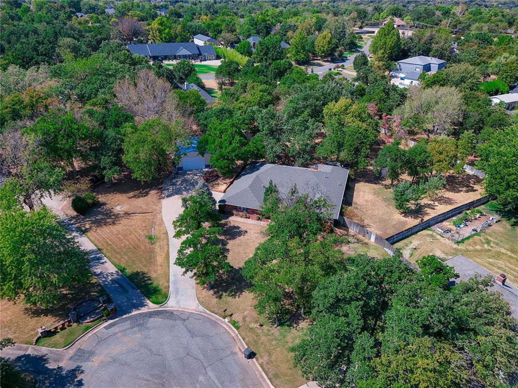 EDMOND MEMORIAL SCHOOL DISTRICT, NEARLY ONE ACRE, HUGE SHOP WITH A PRIVATE DRIVE & NO KNOWN HOA! If you're looking for an Edmond home with a shop and room to spread out, this one stands apart. Located at the end of a cul-de-sac in Tall Oaks Addition, this 2,881 sq ft home sits on a beautiful 0.94-acre lot filled with mature oak trees and offers convenient access to I-35. The oversized insulated shop has its own separate concrete driveway, concrete flooring, electric, new fluorescent lighting and windows—ideal for a workshop, hobbies, equipment, extra vehicles or storage.The home offers 4 bedrooms, 3 full bathrooms and a HUGE bonus room that could easily function as a 5th bedroom, game room, home office or second living area. The kitchen features granite countertops, a walk-in pantry, abundant workspace, double ovens, a 5-burner built-in gas range, stainless steel sink and tile flooring. Vaulted ceilings, exposed cedar beams and a wood-burning fireplace highlight the living room. You'll also find an oversized laundry room and replacement windows throughout the home.Outside, enjoy a huge covered front porch and a backyard designed for both entertaining and everyday use. The hand-laid flagstone patio has two ceiling fans, plus there is a separate pergola for additional outdoor entertaining space. The nearly one-acre lot is fully fenced and includes a full sprinkler system supplied by well water, an additional storage/work shed and plenty of usable yard space. The home, shop and shed all have full guttering. Additional features include an owned water softener and storm shelter in the attached garage. City of Edmond water, trash and electric, ONG natural gas, septic system and private well for irrigation. A rare opportunity to get an Edmond home on nearly an acre with a large shop, separate shop driveway, no known HOA and Edmond Memorial schools!