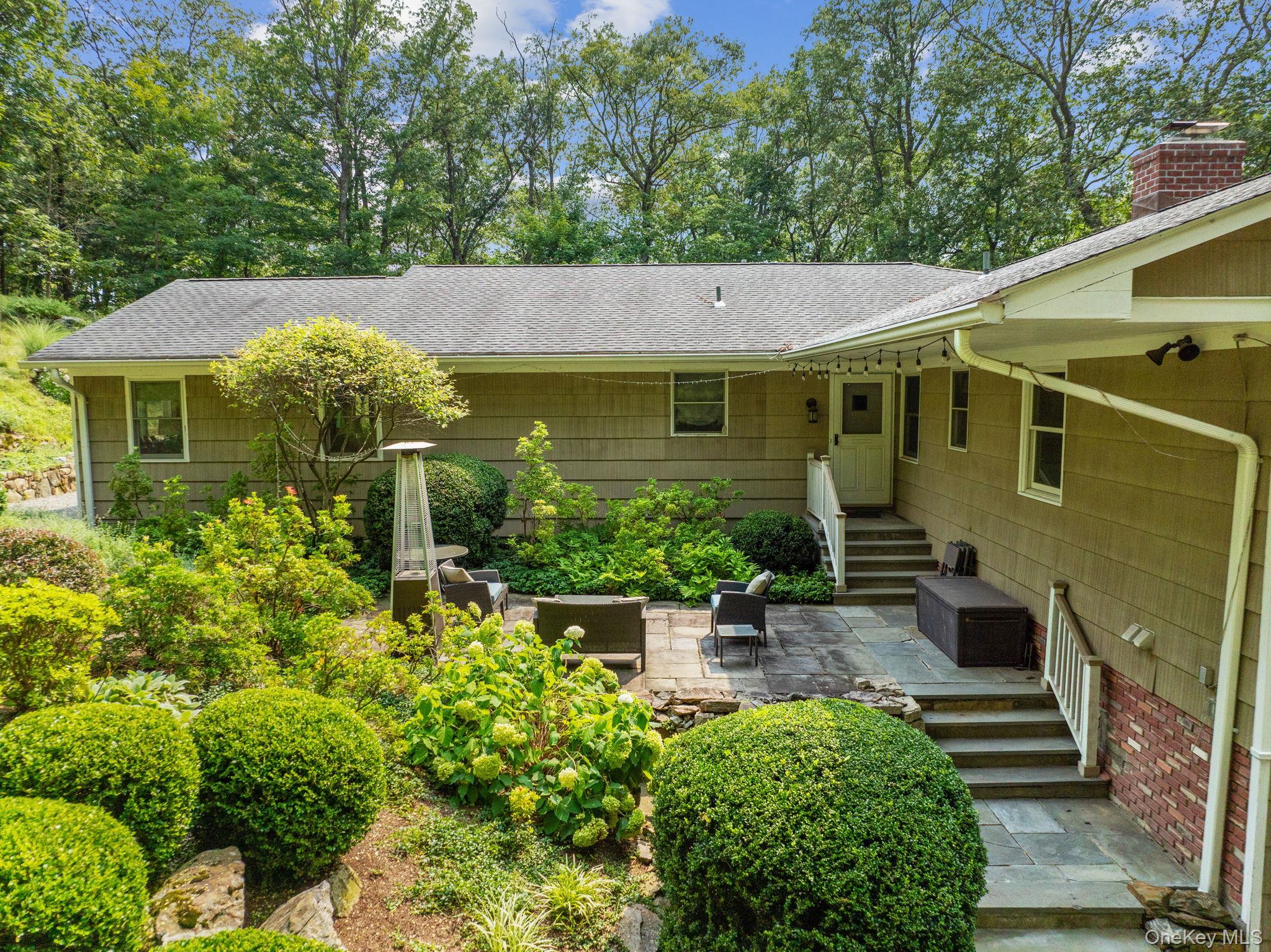 Set privately on 2+ acres at the end of a quiet cul-de-sac, this beautifully updated 4-bedroom ranch lives like a 5-bedroom home and offers the perfect blend of comfort, flexibility, and style. Enjoy distant western sunset views and direct access to the adjacent Pruyn Sanctuary, creating a serene, nature-connected setting while still being part of a neighborhood.The heart of the home is the renovated eat-in kitchen, featuring stainless steel appliances, inset cabinetry, and striking quartzite countertops. It opens seamlessly to a generous breakfast room with vaulted ceilings, walls of windows, and access to the deck—ideal for everyday living and entertaining. The adjacent family room with fireplace provides a warm and inviting gathering space, while the formal many -windowed living and dining rooms offer timeless appeal.The expansive primary suite is a true retreat, complete with vaulted ceiling, a fireplace with custom concrete floor to ceiling beach-wave surround, full-light glass doors to a private patio, a walk-in closet plus 2 additional double closets, and a dressing area with custom built-ins. The spa-like en-suite bath features a steam shower and double sinks with storage vanity and Kohler fixtures. Three additional bedrooms, a home office, and two renovated hall baths complete the main level.The walk-out lower level offers exceptional additional living space with sliding glass doors, including areas for play, media, and a gym, a summer kitchen with granite counters and wood cabinetry, along with abundant closets, a separate laundry room, utility room, and a large storage room. There is a mud room area with built-ins and direct access to a large 2-car garage.Additional highlights include oak floors, 5-zone HVAC, whole house generator, 12-zone sprinkler system, and a flat, fenced yard area. Ideally located close to schools, train, and shops, this home offers a flexible layout, excellent condition, and a truly special setting with patio and bilevel deck, areas for play, gardens and dramatic rock outcroppings.