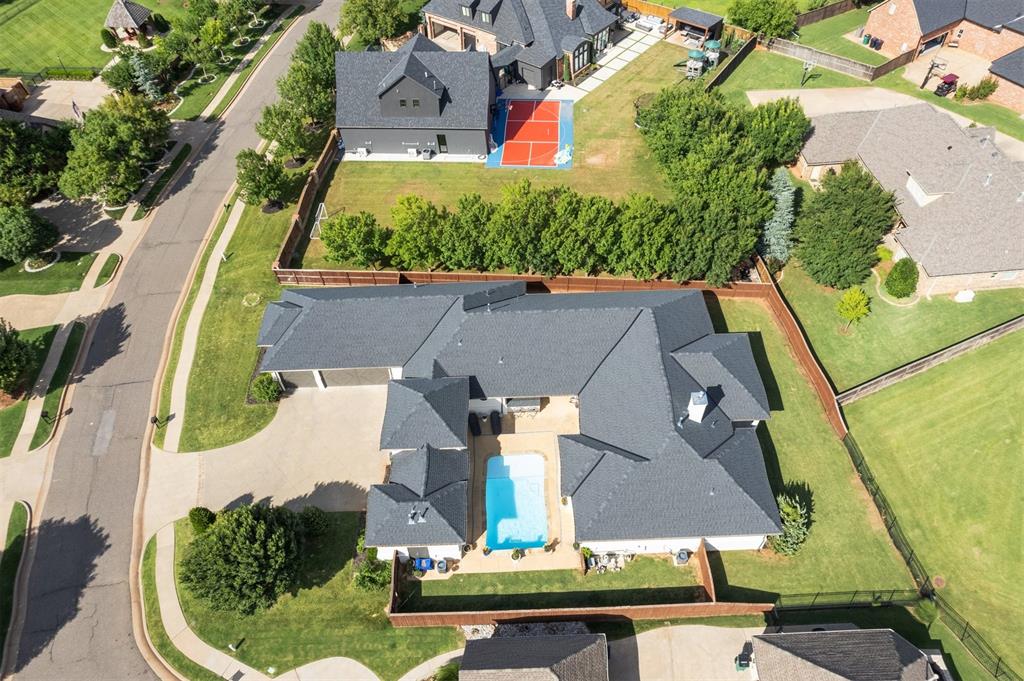 Experience true luxury in the Rose Creek Golf Community with this exquisite contemporary estate featuring a stunning private courtyard pool. Nestled at the back of a cul-de-sac with tranquil pond views, this home offers the perfect blend of elegance & privacy within a 24-hour guarded, gated entrance. An oversized driveway leads to a white-painted brick exterior framed by mature landscaping. Through the custom iron double doors, you'll step into an incredible private courtyard showcasing a custom heated smart-pool complete with waterfall and fountains, the ultimate outdoor retreat. An outdoor kitchen enhances the space, making it ideal for entertaining. Inside, a dedicated foyer opens to the open-concept great room where large windows flood the home with light. Stained concrete floors, crown molding, high ceilings, and sleek modern lighting create a warm modern vibe. The private office features built-ins, wood beams, a barn door, and a decorative floor perfect for work or study. The kitchen is a showstopper with double marble islands, high-end appliances, abundant cabinetry & plenty of seating. A large dining area with a drink station ideal for wine, coffee, and entertaining connects the kitchen and living space seamlessly. The primary suite is a true retreat with rich wood flooring, courtyard access, and a luxurious ensuite with double floating vanities, granite counters, soaker tub, and an expansive walk-in rain shower. Two large walk-in closets add functionality to the elegance. Three additional bedrooms offer ample space for family or guests, all with private baths. The spacious laundry room has counter & cabinet space, and a sink to simplify daily chores. While the home is a masterpiece in itself, Rose Creek’s community amenities elevate the lifestyle even further. Enjoy pickleball courts, a playground, resort-style pool, full gym, clubhouse, arcade, on-site dining, and year-round events like Fourth of July fireworks, sleigh rides, and Easter brunches.