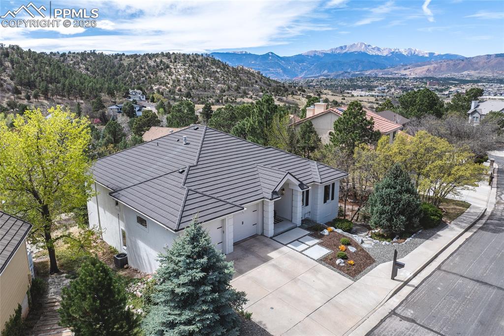 Welcome to your fully remodeled Colorado retreat—where effortless main-level living meets breathtaking views of Pikes Peak from nearly every window. Perfectly positioned in a quiet, private neighborhood just steps from Pulpit Rock Park, this ranch-style home offers the rare combination of peaceful surroundings and unbeatable convenience. Inside, you’ll find a thoughtfully updated interior designed for both comfort and style. The beautifully remodeled kitchen is the heart of the home, featuring stunning leathered marble countertops, updated cabinetry, and a custom coffee bar—perfect for slow mornings or entertaining guests. Rich hardwood floors flow throughout the main level, tying together the open, light-filled living spaces. The primary suite is a true escape, complete with a fully renovated 5-piece bath, a large soaking tub, and a walk-in tile shower with rain head that brings a spa-like feel to your everyday routine. Every bathroom in the home has been tastefully updated, offering a cohesive, timeless look throughout. Downstairs, the walk-out basement expands your living space with a cozy fireplace, two additional bedrooms, and a generous workshop/storage area with incredible potential—ideal for a future home gym, mother-in-law suite, guest quarters, or co-living setup. Step outside onto the back deck and take in those iconic Pikes Peak views—whether you’re hosting friends or unwinding at the end of the day, this space delivers. While the setting feels tucked away and serene, you’re truly in the center of it all. Enjoy easy access to nearby Pulpit Rock Park and trails with a private neighborhood trailhead just down the street. Walk to local favorites like Third Space Coffee and Crunch Fitness, and reach grocery stores, dining, and shopping in just minutes. This is more than a home—it’s a lifestyle. A rare opportunity to own a fully updated ranch in one of Colorado Springs’ most desirable locations, where nature, comfort, and convenience come together seamlessly.
