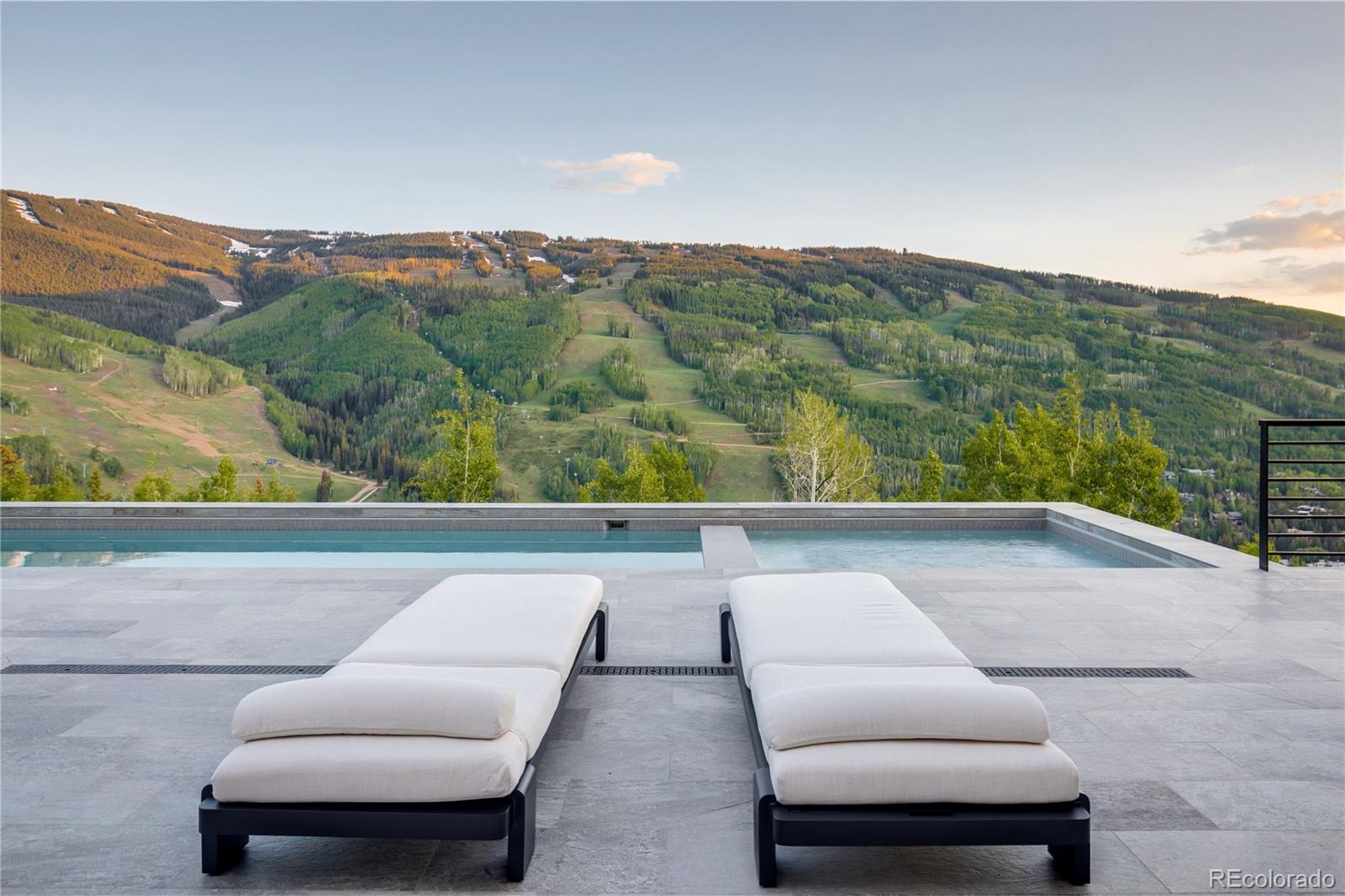 Elevated above Vail in the prestigious gated enclave of Spraddle Creek Estates, 1326 Spraddle Creek Road is a breathtaking new construction estate that redefines modern mountain luxury. Set on 6.37 acres & backed by 23,000 acres of White River National Forest, this 11,260 sf architectural masterpiece was crafted to maximize panoramic views of Vail Mountain while offering an elevated living experience. Every detail speaks to precision, style, & forward-thinking design—from expansive glass walls & clean contemporary lines to the harmonious blend of natural materials that anchor the home in its alpine setting. Inside, the home is a sanctuary of sophistication & comfort. 7 bedrooms & 10 baths are thoughtfully spread across 2 levels, including a main-level primary suite equipped with an oxygenation system designed to improve rest & recovery. The chef's kitchen is outfitted with Sub-Zero & Wolf appliances, a built-in wine dispenser, steam oven, & a discreet back kitchen to keep entertaining seamless. Downstairs, amenities include a gym, steam room, family lounge with bar, & an 8-car auto gallery with Ferrari-designed cabinetry. A full-size elevator & advanced smart home technology bring added convenience to the home's sleek, flowing layout. Outdoor living takes center stage with terraced entertaining spaces that include a rare heated outdoor pool, hot tub, custom fire features, & multiple lounging & dining areas—all framed by unobstructed views of the ski slopes. Designed for both quiet solitude & vibrant gatherings, this is a home that captures the essence of new Vail living: fresh, bold, & timeless. This is not just a home—it's a statement of craftsmanship, innovation, & alpine elegance at the highest level. Embrace this rare opportunity to own a legacy estate where family can come together, friendships are deepened by unforgettable gatherings, business conversations evolve into lasting partnerships, & every moment becomes a memory etched into the alpine air.