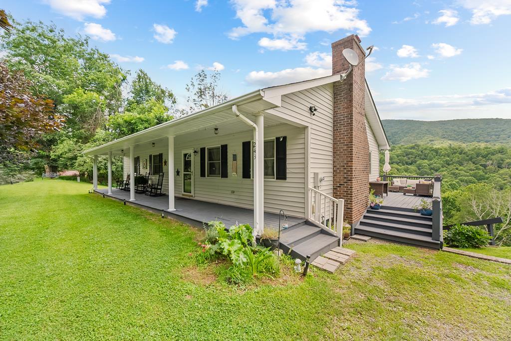 Discover your own slice of mountain paradise in the scenic hills just outside of Independence, Virginia. Nestled on 5 private acres with a small stream, this beautifully maintained 4-bedroom, 3-bath home offers the perfect blend of tranquility, comfort, and convenience. Whether you're searching for a peaceful getaway or a year-round residence, this home checks all the boxes.  Step inside to find an inviting open floor plan, where the living room—anchored by a charming brick hearth with gas logs—flows seamlessly into the dining area and kitchen. Recent updates elevate the space with new tile and engineered laminate flooring, fresh paint throughout, and stylish new countertops. French doors open from the dining room to an elevated back deck—ideal for entertaining or simply taking in the sweeping mountain views and sounds of nature.  Three bedrooms and two full baths are located on the main level, including a spacious primary suite. Downstairs, the walk-out basement features a private bonus bedroom (no windows), a third full bath, and a large den or flex space—perfect for guests, a home office, or a cozy media room. As a resident of this peaceful community, you'll also have access to a serene 9+ acre lake—great for fishing or paddling out in a non-motorized boat. There are light restrictions here with a modest $200/year fee for roads and common area maintenance.  Living in Independence means embracing a lifestyle rooted in Appalachian charm. This historic town is home to annual festivals, local shops and cafes, and just a short drive from outdoor treasures like Grayson Highlands State Park, the New River, and the Virginia Creeper Trail.  Conveniently located within a two-hour drive of several major cities: Roanoke, VA, Charlotte, NC, Winston-Salem, NC, Blacksburg, VA, and Boone, NC With natural beauty, privacy, and modern comfort, this home is a rare find in the Blue Ridge Mountains. Come experience the magic of mountain living—schedule your private showing today.