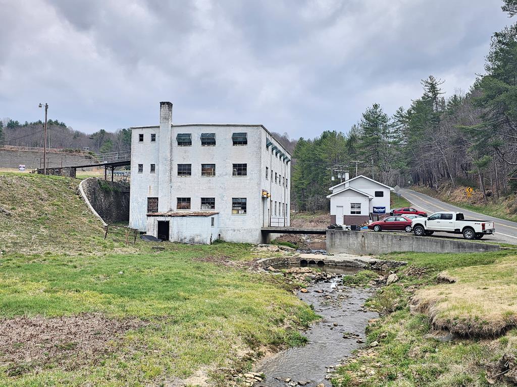 This versatile commercial property in Fries, VA offers unlimited opportunities directly across the road from the scenic New River and the New River Trail. The property features a 2-bay shop with an office which is currently rented, bathroom, and wood heat, ideal for a variety of business or workshop needs. In addition, a substantial three-story building provides even more potential: the first level has a large open area with high ceilings, a garage door, and access doors; the second level includes another spacious open area with a partition wall and bathrooms; and the third level offers three partitioned rooms along with additional bathrooms. Whether you're looking to expand a business, invest, or create a unique multi-use space, this property is full of possibilities. Property is being sold in AS-IS condition. Call Today!