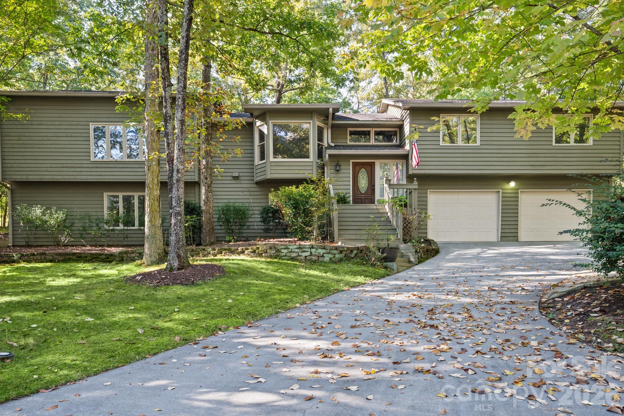 Welcome to 16 Woodvine Lane, where space, privacy and the Lake Wylie lifestyle come together in the sought-after gated community of River Hills. Tucked away on a wooded cul-de-sac lot, this 5-bedroom, 4-bath home offers nearly 3,200 square feet and a flexible layout designed for the way you live today. The main level features the primary suite plus three additional bedrooms, a bright living area and formal dining space. Downstairs, discover an entire second living area with a spacious recreation room, wet bar and additional bedroom, creating incredible possibilities for guests, multigenerational living, a home office, media room or entertaining space. Outside, the expansive 28-foot screened porch overlooks the private, tree-lined backyard and offers the perfect place to relax or entertain. River Hills delivers an exceptional Lake Wylie lifestyle with 24-hour gated security, walking trails, playgrounds and beautifully maintained community spaces. Optional River Hills Country Club membership offers access to golf, tennis, fitness, swimming and dining, while the community marina provides access to boating and life on Lake Wylie. Located in the Clover School District with easy access to Lake Wylie, shopping, dining and Charlotte, this is more than a home. It is an opportunity to make one of the area's most established communities your own.