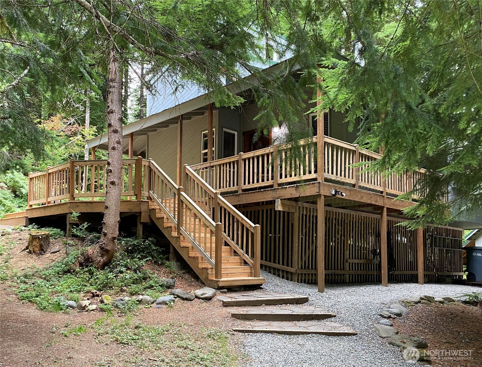 Ultimate privacy awaits on 5+ acres in the highly sought-after Crystal River Ranch community—this private timber frame retreat is tucked away among towering trees, offering a rare blend of seclusion, charm & opportunity.  One of the largest lots in CRR invites you to unwind & reconnect with nature. Watch for the elk herd who visit the property, adding to the magic of this one-of-a-kind setting. Whether you’re looking to create lasting memories, invest in a proven rental or desire a personal escape-opportunity truly knocks. Currently operating as a solid 5-star rated short-term rental for 6 months, this turnkey property is ready for immediate enjoyment or continued income potential. Inside, the cedar home showcases soaring vaulted ceilings, exposed beams & a wall of windows that fills the living space with natural light. The spacious, updated kitchen features granite countertops & an abundance of cabinetry. Fully equipped—including dishes & essential kitchenware, D/W, fridge & W/D. The home is offered fully furnished & accommodates 6 guests with a main-level bedroom & two additional sleeping rooms upstairs. A full bathroom is upstairs, with a half bath on the main floor. The property includes a 12 x 20 shop/storage building with a separate office area—ideal for remote work, hobbies, or storage. Outside enjoy the new cedar deck, gazebo & fire pit—perfect for entertaining or soaking in the tranquility of your surroundings. Close to Mt Rainier National Park & Crystal Mtn Ski Area