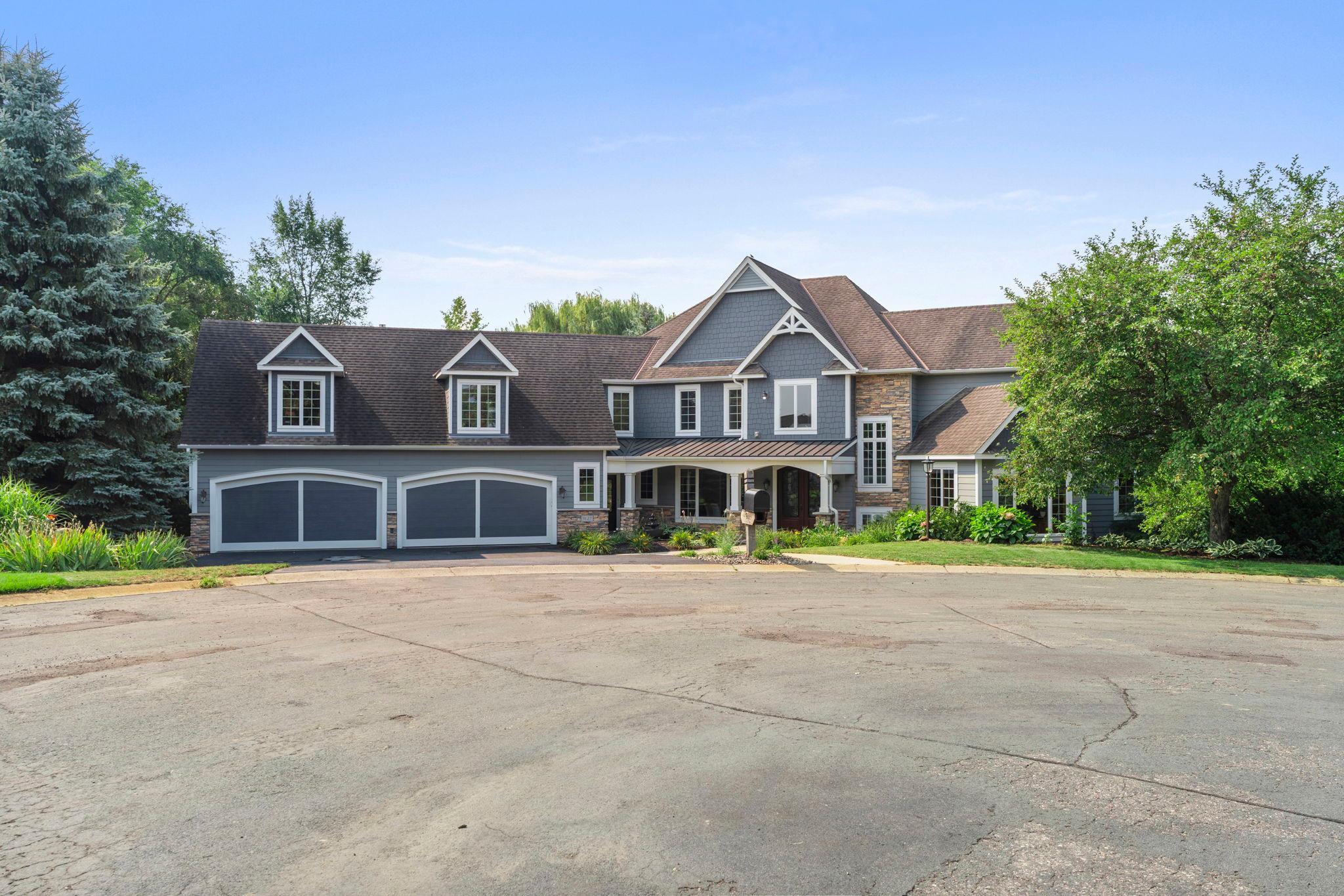 Located on a private cul-de-sac in Inver Grove Heights, this seven bedroom, seven bathroom home spans three finished levels connected by a private elevator, minutes from downtown Saint Paul. The main level features a tiled foyer, a formal dining room with coffered ceiling, and a living room with 18 foot ceilings and a stone fireplace with built-in cabinetry. The updated kitchen includes stainless steel appliances, a pot filler, double wall oven, and a center island with breakfast bar seating, opening to an informal dining area and a vaulted sunroom with deck access. Also on this level: a laundry room, powder bathroom, storage closet, and four car heated garage. The primary suite offers vaulted ceilings, deck access, a fireplace, and an en suite bathroom with soaking tub, walk-in shower, dual vanities, and walk-in closet, plus an adjacent office. The upper level holds four bedrooms with private bathroom access, a laundry room, and a study nook, along with a fifth bedroom in a private apartment above the garage with its own kitchen, fireplace, dining and living areas, and full bathroom. The walkout lower level centers on a stone fireplace and opens to a patio and fenced in-ground pool, with a wet bar, game area, and storage rooms. The sixth bedroom offers pool views, and the seventh sits near a full bathroom with exterior access serving as a pool bath. Outdoor spaces include the pool patio, a deck, and front patio, on a landscaped lot. The driveway was sealcoated in 2026.