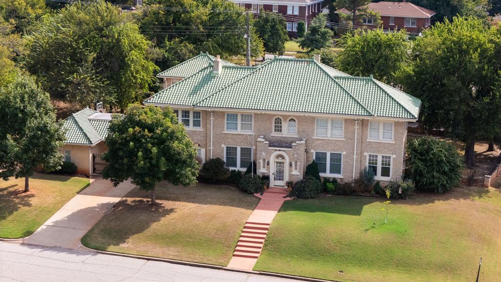 Welcome to 600 Culbertson Drive in the coveted Lincoln Terrace neighborhood. This architecturally stunning, buff-brick residence with green Spanish tile roof is perched high above Lincoln Boulevard and surrounded by mature cedar trees. Originally built for General William S. Key—a prominent figure in Oklahoma’s political and military history—this home is rich in heritage and timeless craftsmanship.

Inside, you'll find elegant formal spaces including two living rooms, a formal dining room, and a stately study featuring a rare Frankoma fireplace. The updated chef’s galley kitchen boasts stainless steel appliances including a Jenn Air range, built-in ice maker, along with a cozy breakfast nook. Hardwood and tile floors flow throughout the main level, adding warmth and character.

Upstairs, all four spacious bedrooms await—including a luxurious primary suite with a fireplace, expansive walk-in closet, and en suite bathroom with a large walk-in shower. Two of the bedrooms feature fireplaces, and a convenient upstairs laundry room with built-in counter space adds modern ease.

The home’s historic details shine: brick-arched first-floor windows with basket-weave trim, a welcoming vestibule entry with coat closets, and charming arched windows and doors. A gated drive leads to the detached garages and backyard with open patio—perfect for entertaining.

Additional features include a two flex rooms, a large basement offering abundant storage, and a detached garage apartment (sold as-is). Neither the basement nor the garage apartment is included in the home’s listed square footage, providing added value and future possibilities.

All of this is located in the heart of Oklahoma City’s historic Lincoln Terrace, just minutes from the State Capitol, OU Health Sciences Center, and the vibrant Medical District.

Don’t miss this rare opportunity to own a piece of Oklahoma history.