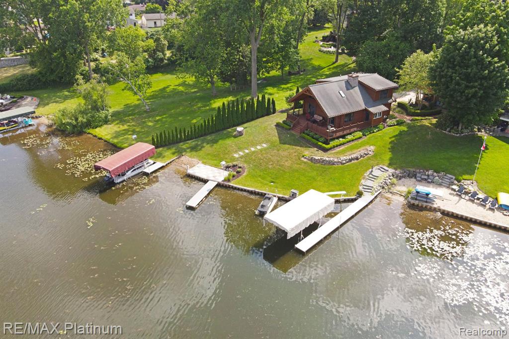 Welcome to this stunning Heritage Log home with 79 feet of lake frontage on all-sports Woodland Lake. Nestled on a rare and deep 478-foot lot, this turnkey property is filled with charm, warmth, and functionality. The home features 2 bedrooms and 2.1 bathrooms, along with a full finished basement that includes a custom wine cellar and a spacious cedar closet. Natural wood details and custom finishes create a cozy yet upscale retreat perfect for year-round living or a relaxing getaway. Two impressive 1,000 sq ft garages provide exceptional versatility. The primary garage is paneled and doubles as a great space for entertaining on rainy lake days, while the second garage offers generous storage for recreational equipment, vehicles, or personal collections. Nearly everything is included in the sale, making this a true move-in-ready home with immediate occupancy available. Located just minutes from expressways and downtown Brighton, the property offers both privacy and convenience. Whether you're seeking a full-time residence, a seasonal retreat, or an investment opportunity, this unique lakefront offering stands out as a rare find on highly desirable Woodland Lake.  BATVAI