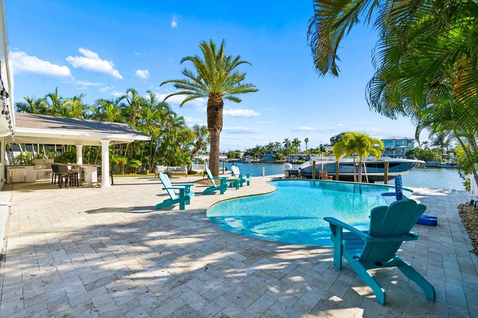 Experience the ultimate in luxury waterfront living at 352 Hermosita Drive in St. Pete Beach. Just renovated and beautifully appointed, this exceptional ranch-style residence blends timeless Florida charm with sophisticated modern finishes, all set against a stunning waterfront backdrop. Gorgeous terrazzo floors, brand-new marble kitchen countertops and backsplash, and a newly renovated primary bathroom elevate the interior with style and elegance. All impact windows and sliders to yard and a new roof installed in 2025 adds peace of mind. The inviting open living spaces and enclosed sunroom create an ideal setting with wide open waterviews for everyday comfort and entertaining.Step outside to your own private tropical oasis, where a large heated saltwater pool with new equipment takes center stage, surrounded by an expansive outdoor entertaining area. The expansive backyard is designed for exceptional outdoor living, featuring a covered bar and grilling kitchen, plus a waterfront turf putting green with three holes for practicing your short game while enjoying the water views. Boating enthusiasts will appreciate approximately 70 feet of waterfront and an oversized grandfathered-in dock featuring an impressive 30,000-pound boat lift, with ample space for kayaks and paddleboards. This is the quintessential waterfront lifestyle, with boating, swimming, and outdoor entertaining right in your backyard.Ideally located just minutes from the pristine sands of Pass-a-Grille Beach, local shops, and popular restaurants, this remarkable property also offers convenient access to I-275, vibrant downtown St. Petersburg, and Tampa International Airport. A rare opportunity to own a newly renovated luxury waterfront retreat in one of the area's most desirable coastal settings.