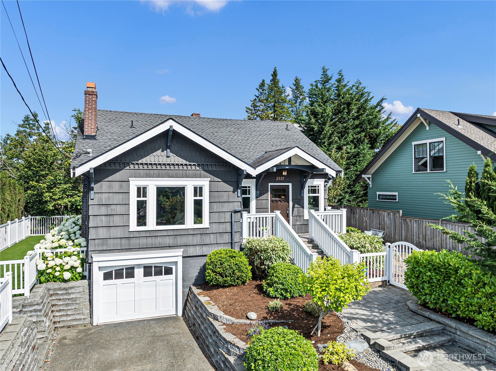 This tastefully renovated 1927 Craftsman Bungalow features original architectural details, oak and fir floors, coved ceilings, a wood burning fireplace, updated plumbing and electrical and a newer HVAC system for heating and cooling. The main level includes a generous entry foyer, a large formal living room, a separate dining room and an updated eat-in kitchen with stainless appliances and ample cabinet storage. The dining room provides access to a side patio and yard, ideal for entertaining.  Two bedrooms and an updated full bathroom with separate tub and shower are located on the entry level. Two additional bedrooms are located upstairs along with another updated bathroom with tub/shower combo.  The lower level features a spacious family room, a laundry room, access to the attached one car garage and an exterior door to the patio and fully fenced yard. The property also includes mature landscaping, raised planting beds and additional parking in the driveway. Convenient North End location offers easy access to Proctor, Point Defiance and the waterfront.