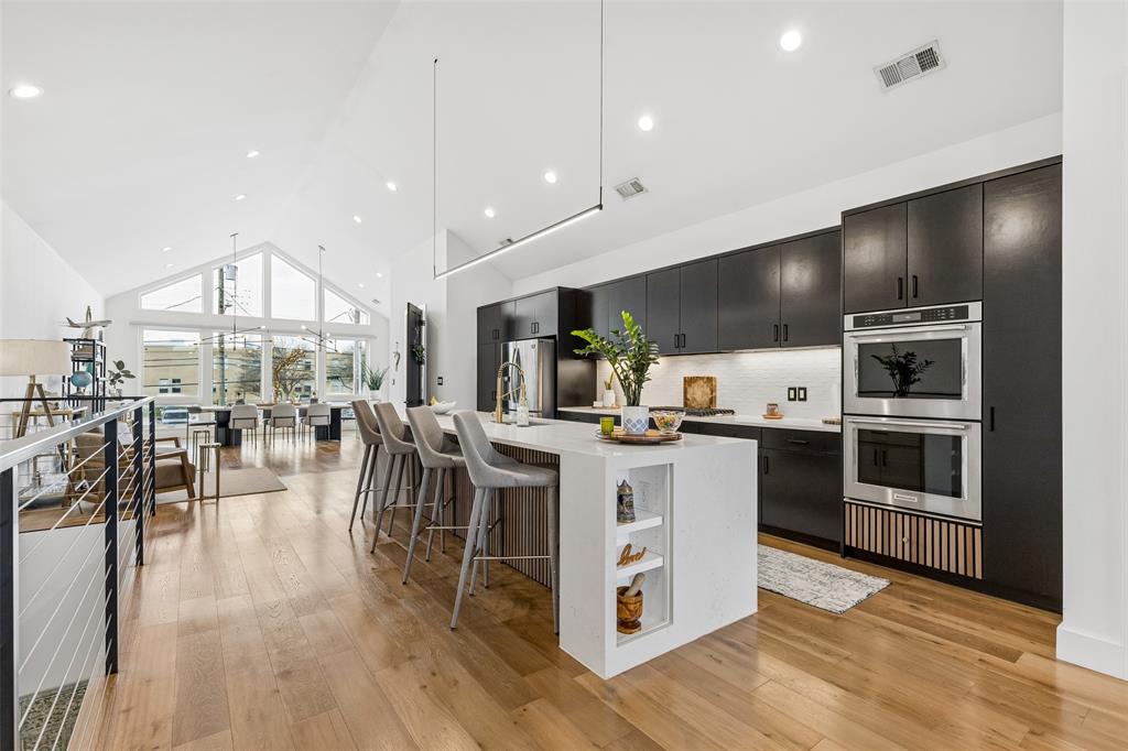 STUNNING single-family attached home WITH A POOL in the heart of East Uptown just moments from The Central, one of the city’s most transformative new mixed-use developments. Ultimate lock-and-leave with a custom oasis pool! Designed for elevated living & sophisticated entertaining, this two-story townhome features dramatic soaring ceilings in the main living area, with floor-to-ceiling windows, genuine hardwood floors & museum-finished walls. Electronic filtered blinds, custom lighting & curated architectural details enhance the refined look. The state-of-the-art kitchen anchors the home with a striking Quartz waterfall island, stainless steel appliances, gas range, double ovens, custom wood accents & sleek contemporary fixtures. The first level features two ample-sized bedrooms ideally suited as offices, media, or guest rooms & an expansive primary suite which overlooks the private, resort-style pool. The spa-inspired primary bath showcases an open-concept wet room design with a freestanding soaking tub, elevated shower features & custom motion-activated lighting. Custom closets, a well-designed laundry room & dual HVAC systems provide optimal efficiency & comfort year-round. Impressive outdoor living features a private balcony off the living room which overlooks the custom-built pool & features a slate fireplace- a seamless extension of the interior living space. The beautiful heated & chilled pool is finished with opalescent tile and a waterfall feature, delivering year-round enjoyment and a boutique-hotel ambiance rarely found in Uptown townhomes. Additional highlights include an attached two-car garage with epoxy-coated flooring & upgraded storage systems. A rare opportunity to own a one-of-a-kind luxury townhome with private pool in East Uptown, located in a rapidly appreciating neighborhood. Meticulously designed, architecturally striking & no detail overlooked!