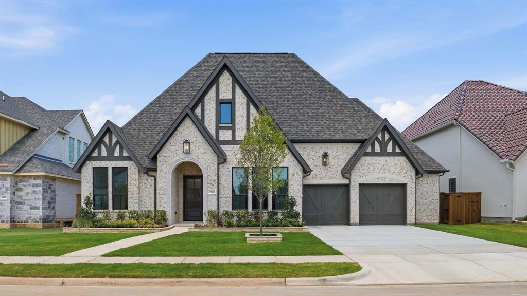 Extended entry leads to open kitchen, dining area and family room. Kitchen features walk-in pantry, double wall oven, a wet bar, Butler's pantry and island with built-in seating space. Dining area flows into family room with wall of windows and a wood mantel fireplace. Hardwood floors throughout main living area. Game room with wall of windows just off family room. Primary suite includes bedroom with wall of windows. Primary bath includes dual vanities, a freestanding tub, elongated separate shower and two walk-in closets, one with access to utility room. Guest suite offers private bath. A Hollywood bath adjoins second and third bedroom. Soaring ceilings and abundant closet space add to this generous four-bedroom design. Covered backyard patio. Mud room leads to three-car garage.