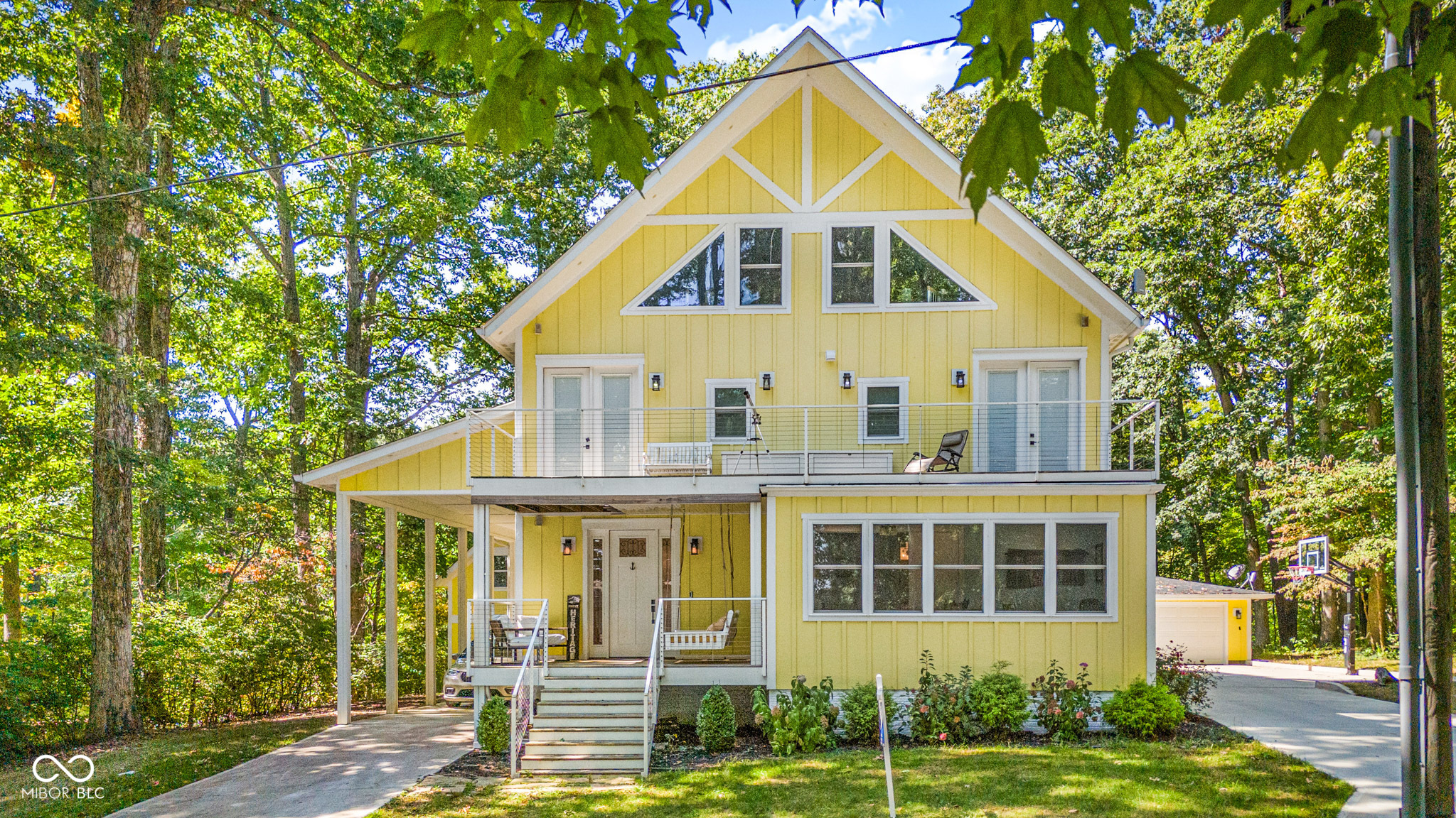 This stunning home sits on two spacious lots and offers the perfect blend of comfort and outdoor living. Featuring 3 bedrooms and 3.5 baths, it showcases soaring 35' ceilings and breathtaking water views with a seawall along the shoreline.  The main-level master suite is a true retreat, complete with a spa-like shower featuring a sauna and an oversized tub you have to see to believe. Just off the master, a private home office offers inspiring views of Raccoon Lake.    Upstairs, two expansive bedrooms each feature full-length balconies, while a finished bonus room provides endless possibilities-perfect for a guest suite, office, or recreation space.    The wooded setting provides privacy and natural beauty, while the RV carport and large boat building ensure plenty of space for all your toys. Sports enthusiasts will love the half-court basketball setup, and the covered porch is the perfect spot to relax and soak in the serene water views. The lot north of home is included and is .50 acre. Total of 1 Acre