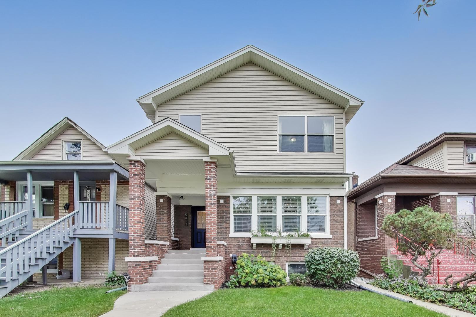 Welcome to this beautifully reimagined contemporary Chicago home in the heart of Portage Park. Originally a classic bungalow, this residence has been graciously expanded with a full second story addition and a finished lower level. A perfect layout for modern city living with 5 bedrooms, an additional versatile room for an office or creative space, and 3.5 baths. Step past the brick pillars at the front door and enjoy an open floor plan with hardwood floors and draped custom window treatments. Moving through the main floor, you are greeted by the newly renovated kitchen featuring opulent lighting fixtures, sleek cabinetry, granite countertops and premium stainless steel appliances. A space ideal for everyday meals and entertaining guests. Upstairs, take in the primary suite with architectural built-ins leading to ample walk-in closet space and a double vanity en-suite bath. Enjoy alfresco dining on the attached deck, fully designed with locally crafted wooden benches that blend style and functionality. Tailored privacy screens create a secluded atmosphere. This outdoor haven invites long conversations, morning coffees, and weekend BBQs. From there, walk into the fully fenced yard leading to a 2-car detached garage, complemented by an additional carport for a third vehicle or flexible use. For added protection and peace of mind, home comes equipped with a comprehensive security system including the addition of seven wired external IP cameras. Homeowners have meticulously maintained every corner of this home. A true gem located just steps away from Portage Park, Target, Jewel, Aldi, cafes, restaurants, and boutique shops. Also conveniently located near public transportation and the Kennedy expressway.