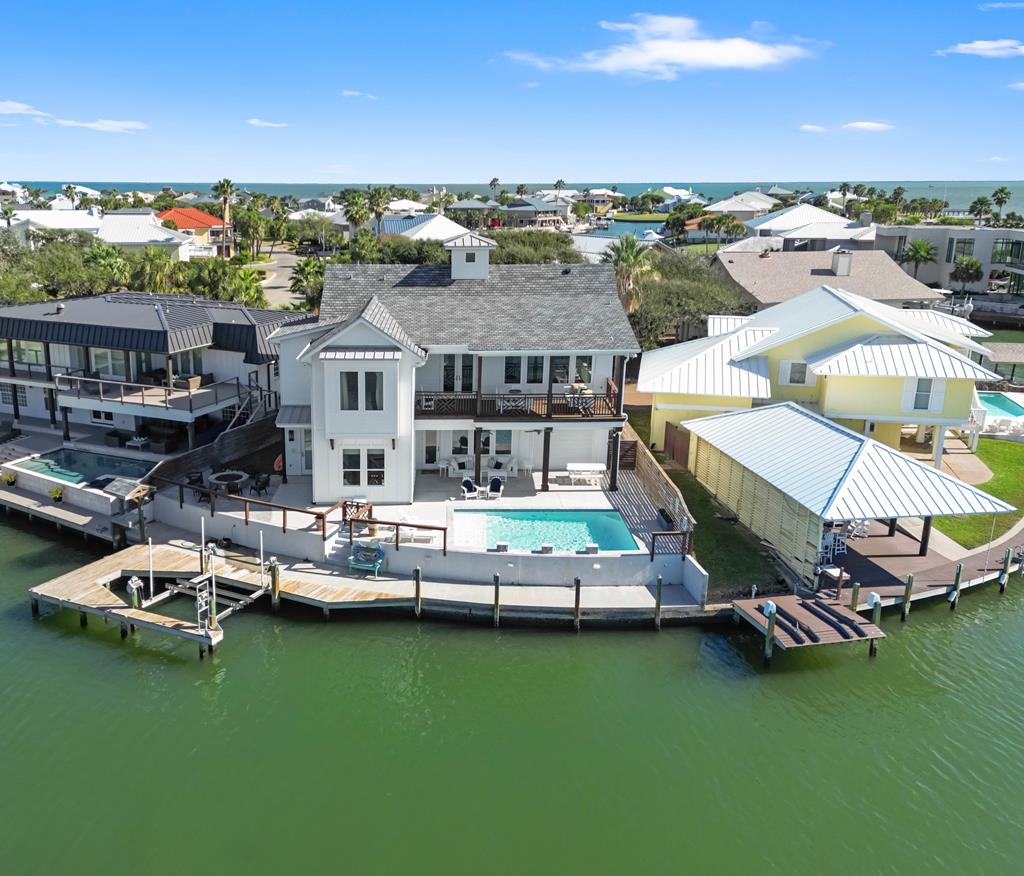 WELCOME TO PARADISE!! Breathtaking views of Little Bay, Rockport Beach and Aransas Bay. The first level you will have 1 bedroom with build in bunkbeds, full bath and a family/media room overlooking the water. The second level you will find a beautiful open living and kitchen area. In the kitchen you have engineered counter tops, walk in pantry with reclaimed doors and ample cabinet space.  Your private primary bedroom features a stunning tiled shower, his and her sink, quartz counter tops and 2 walk in closets. Outside you will be able to relax in your dual system swimming pool with endless views. Boat lift, tank less water heater, tackle room, boat lift, ice maker and so much more! This Coastal home is truly a must see.