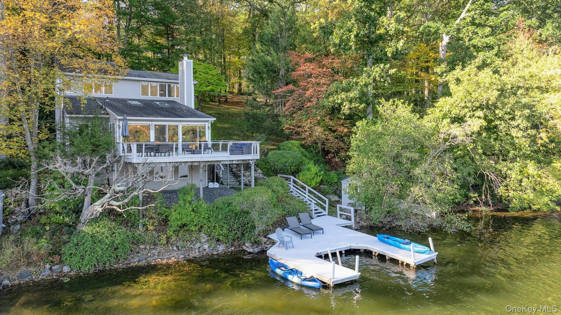 Magical lakefront retreat!  Spectacular well maintained contemporary home located on Lake Oscaleta with 146 feet of direct lake access.  Bright three level VIEW home.  Soaring ceilings, skylights, floor to ceiling windows, wood-burning fireplace, and private setting.  Wrap around view deck.  Flexible floor plan.  Main floor with kitchen, spacious living room/dining area, den, bedroom, and full bath.  Upper level has spacious master suite, with dressing area, bath and expansive lake views.  Lower level has full bath and space perfect for guests or private office with separate entrance.  Connected by direct access to Lake Waccabuc and Lake Rippowam.  Fresh water lake!  U shaped dock perfect for water lovers!  Swim, boat, fish, and ice skate - year-round outdoor enjoyment.  This amazingly special view home will not last!  Sale includes two lots.  Lives as a three bedroom.