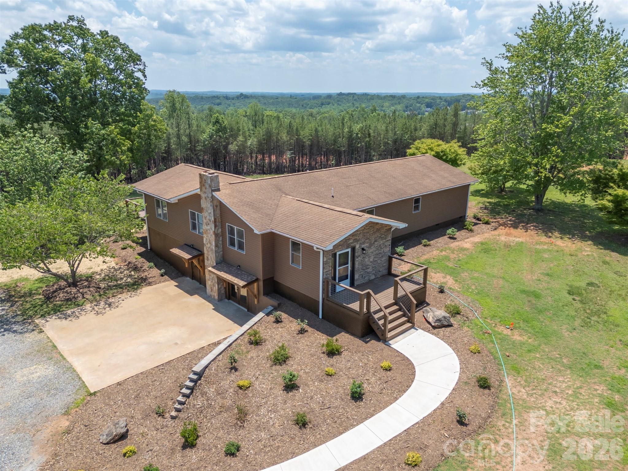 Escape to your own private hobby farm up a long driveway off Highway 9 on 10.09 unrestricted acres, with direct access to the CETA trail system right outside your door. Here, single-level living meets total peace of mind — bring your animals, your hobbies, and your vision, with no covenants or restrictions to hold you back. The home is bright, with large windows and sliding doors that let light and the long-range views in. The dining room/sun room has vaulted ceilings, and so does the main bedroom. The main bedroom also features an extra-large walk-in closet, a new south-facing deck, and its own bathroom with a washer/dryer hook-up. This home has been extensively and thoughtfully updated throughout, starting with the major systems: a new septic system, a new Armstrong heat pump HVAC system, all new plumbing and lighting fixtures, a new hot water heater, a new foundation block wall beneath the dining area, and fresh insulation under the dining room, primary suite, and foyer. The full basement has been completely waterproofed and offers abundant storage, a half bath, and a charming old woodstove for cozy nights in and a new French-door walkout to the yard.Inside, you'll find a beautifully renovated tile-and-glass shower, new LVP flooring in the guest bedrooms, and fresh interior paint throughout. Outdoors, the property has been just as carefully refreshed, with three brand-new decks and handrails, a new retaining wall, fresh landscaping, and a new sidewalk leading to the home. A fully updated shed — with new siding, paint, and shingles — rounds out the package. Two additional acres have been cleared, offering plenty of room to roam, garden, or raise animals, while mature blueberry bushes are already established and ready for next season's harvest — chickens optional, but highly recommended. Spend your evenings on one of three decks, watching the kids and dogs play across your own private acreage, or set out on the CETA trail right from home.Despite the seclusion, convenience is never far away: a store is just one minute from your driveway, and both I-74 and I-26 are within a ten-minute drive for an easy commute.