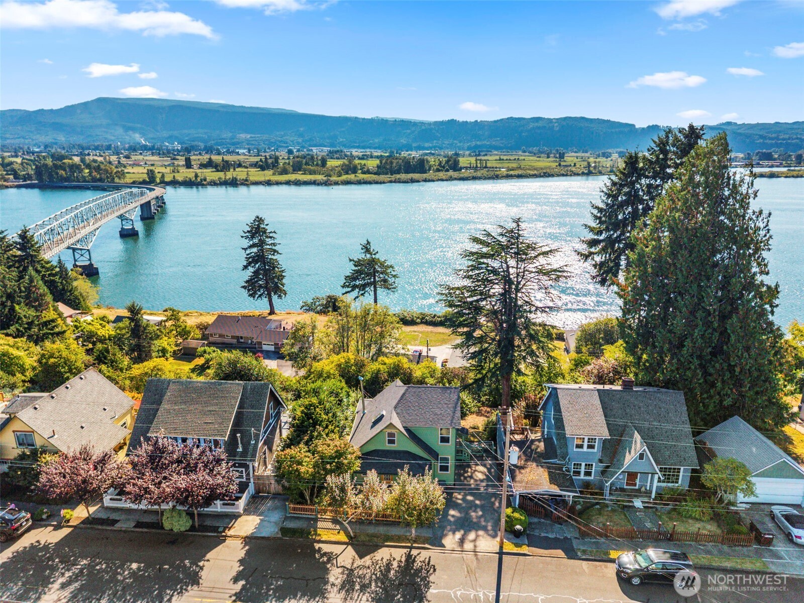 Columbia ST Overlook! Discover what the buzz is all about - NEW ROOF, FRESH PAINT, NEW APPLIANCES & simply AHH-MAZING sunsets & stunning Columbia River views on every level of this 1920's charmer just above the Town of Cathlamet. High bank island, territorial & bridge vistas! Perfect multi-generational setup or income producing opportunity featuring open-concept main level inclusive of warm & welcoming entry, 1/2 bath, GREAT room curved feature wall, dining hub, well-equipped entertainer's kitchen with endless picture windows of the expansive waters of Cathlamet Channel & Puget Island Bridge; oversized laundry, huge storage closet, lovely coffee bar and side door to parking or stairs to lower level. Curved wall of great room continues upstairs in spacious primary w/those same mesmerizing views, craft room/closet or hidden office; secondary bedroom (or den) & full bath (tiled floor, walls & shower). With its separate exterior entrance, pop down the stairs and discover fabulous basement living quarters w/full kitchen, full bath, large bedroom, a living room with built-in storage and wall of windows to take in more of those splendid views! Mature, lush backyard full of producing fruit trees, shade trees & patio to peek at those views, birdwatch or listen to the sounds of nature & consider the day's events. Trek downtown, bicycle to Puget Island, walk to the park? Jump on the chance to own this beautifully appointed home on desirable Columbia St before the opportunity slips away!