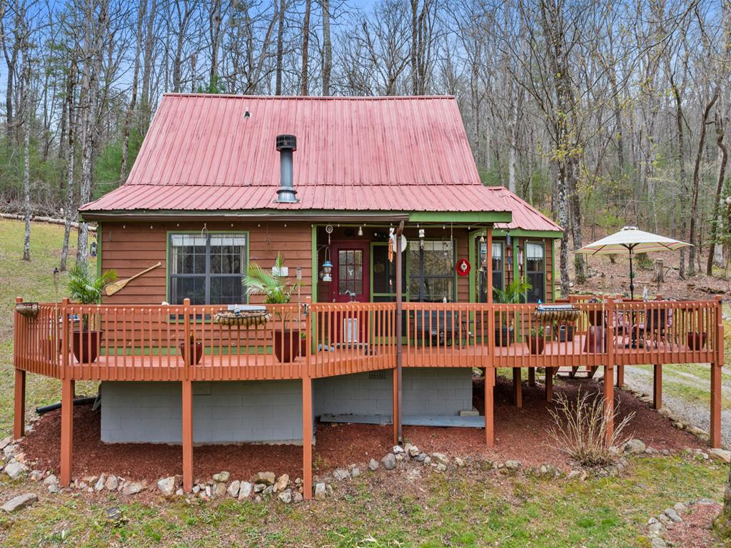 Tucked just minutes from the heart of the Aska Adventure Area, this inviting cabin offers the rare convenience of easy access with no steep mountain roads—just two simple turns off Aska Road and you're there. Inside, the 2-bedroom, 2-bath retreat radiates warm, uplifting energy. A striking spiral staircase winds upward to a spacious, open loft bedroom that feels like a private hideaway among the treetops. In the main living area, a charming built-in bar sets the tone for relaxed evenings where it truly feels like it's always five o'clock somewhere. The property itself is wonderfully gentle and usable, making it ideal for families, friends, or rental guests looking to unwind and explore. Whether you're seeking a personal getaway, a great place to park your RV, or a strong short-term rental opportunity, this cabin offers a promising investment with plenty of mountain-town magic.