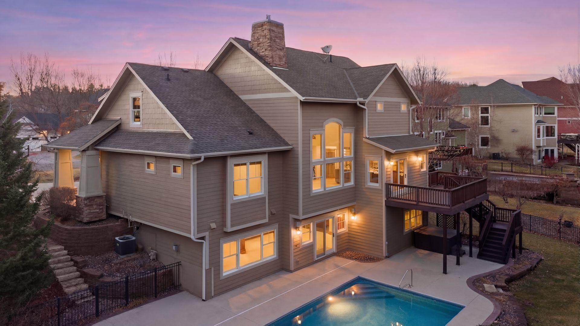 Nestled in a peaceful cul-de-sac neighborhood, this timeless Craftsman home blends elegant design, custom craftsmanship, and serene natural surroundings. Abutting a private, tree-lined pond, the property offers a peaceful water backdrop and rare sense of privacy that makes the setting feel like a retreat. Inside, the open concept layout creates expansive, yet comfortable living spaces designed for both everyday living and entertaining. The two-story great room features a dramatic coffered ceiling, impressive gas fireplace with natural stone to the ceiling, and a wall of oversized windows that fill the home with natural light while showcasing tranquil backyard views. Refinished maple and oak hardwood floors, birch cabinetry, and extensive built-ins throughout highlight the home’s exceptional millwork and architectural detail that make the home feel warm and distinctive. The spacious gourmet kitchen is both stylish and functional, featuring rich cabinetry with black accents, a massive center island, walk-in pantry, and professional appliances, while a formal dining room offers an elegant setting for gatherings. Also sure to please is the main-level Owner’s suite with all the expected luxuries, including a spa-like en suite with outfitted walk-in closet, as well as a mudroom with built-in lockers making daily organization a breeze. Upstairs, an open catwalk overlooks the great room and leads to three bedrooms and two full baths, along with a desirable laundry room and huge bonus room with endless options of use. Creating the perfect extension of the home’s entertaining spaces, the lower level features a cozy family room with stone surround gas fireplace, walk-behind wet bar with game area, and a versatile fifth bedroom/office, ¾ bath, and bonus room that provide flexibility for guests, hobbies, or additional workspace. And just outside the walkout, you’ll find a backyard oasis that’s sure to be one of your favorite places to unwind and entertain with an in-ground pool ready for summer pool parties, spacious pool deck with hot tub for relaxing evenings, and a maintenance-free deck that overlooks the lush, private landscape and tranquil pond with frequent wildlife sightings. Conveniently located just minutes from I-94, shopping, and top-rated East Ridge schools, this home is truly move-in ready with extensive improvements inside and out- including all new paint, carpet, siding, and roof- offering comfort, beauty, and peace of mind for years to come.