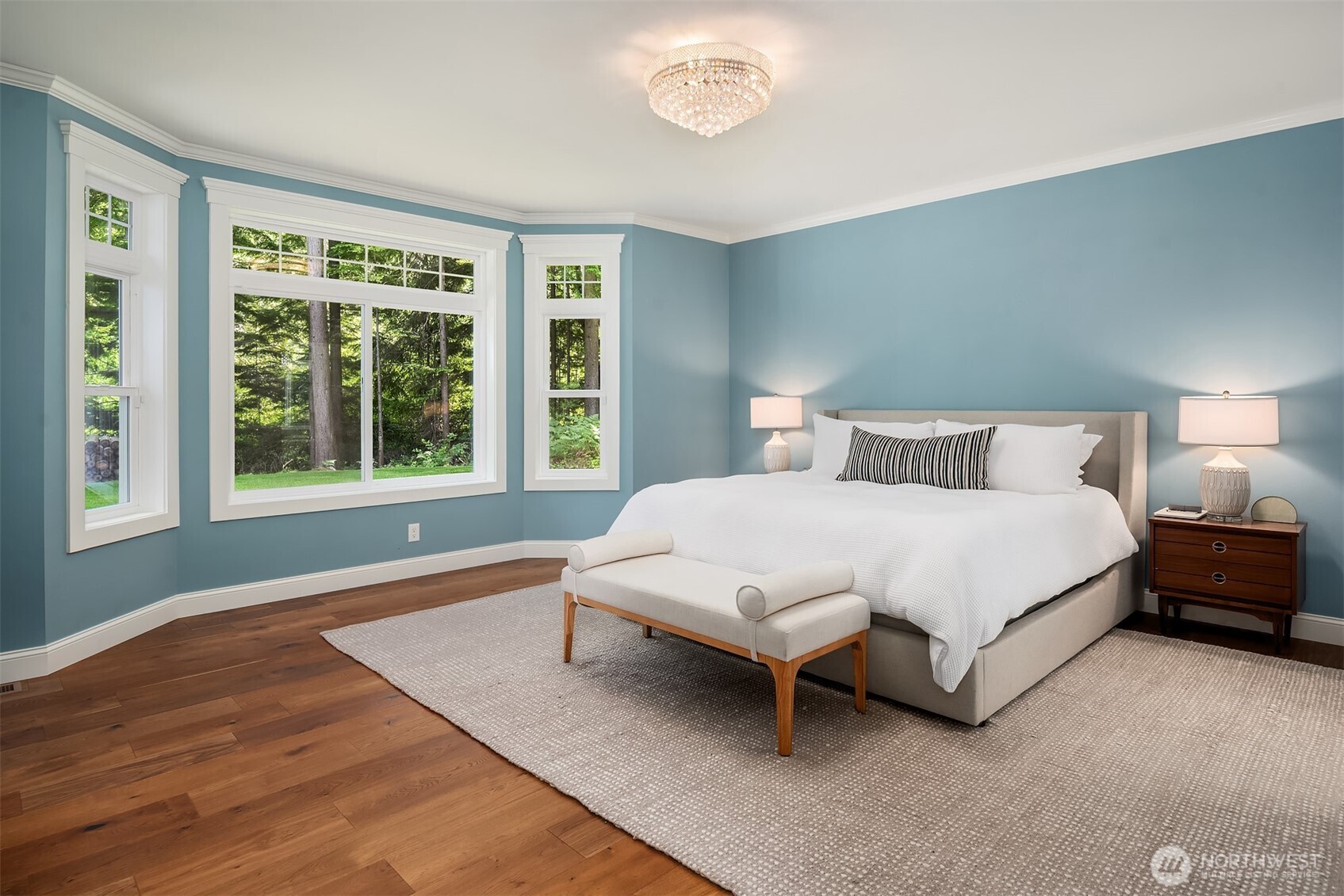Spacious primary suite with peaceful views, abundant natural light, and a relaxing retreat overlooking mature evergreens.