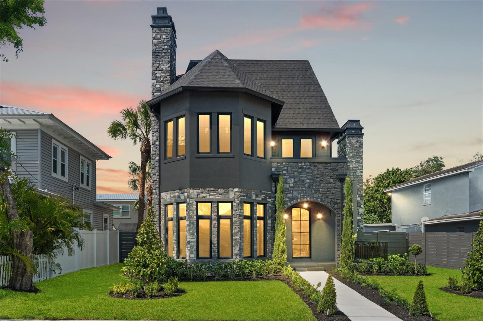 As seen on HGTV's 100 Day Dream Home! Welcome to 807 W Park Ave, a one-of-a-kind residence built by VIKIN Homes in the heart of Ridgewood Park—where timeless Gothic Revival architecture meets modern luxury. This brand-new, meticulously crafted 5-bedroom, 5.5-bathroom home offers an extraordinary blend of classic design elements and cutting-edge finishes, creating a living experience unlike any other. This stunner boasts five spacious ensuite bedrooms with custom walk-in closets across three floors. Floor one is adorned with mostly common space including your two-toned designer kitchen, dining room, living room, fully built out pantry and built-in mudroom. Floor two is where you go to rest and reset by way of the primary and two separate auxiliary bedrooms. Floor three wraps’ things up by offering more sanctuary with two additional bedrooms and an oversized flex room that hosts ample cabinet and countertop space along with refrigeration. Whether you utilize it as a media room, game room or playroom, its location on the third floor will ensure its occupants aren’t disturbing anyone else in the home. Enjoy panoramic views of downtown Tampa and the Ridgewood Park Butterfly Garden from your private balcony—perfect for morning coffee or evening sunsets. Location is prime being just one block away from the beautiful Hillsborough River and the vibrant Armature Works property, offering access to Tampa's finest dining, shopping, and cultural attractions. This home blends the grandeur and charm of Gothic Revival design with modern, high-end amenities. With its towering spires, arched windows, intricate stonework, and high ceilings, it’s a rare find in the dynamic Ridgewood Park neighborhood. This is more than a home….it’s a lifestyle.